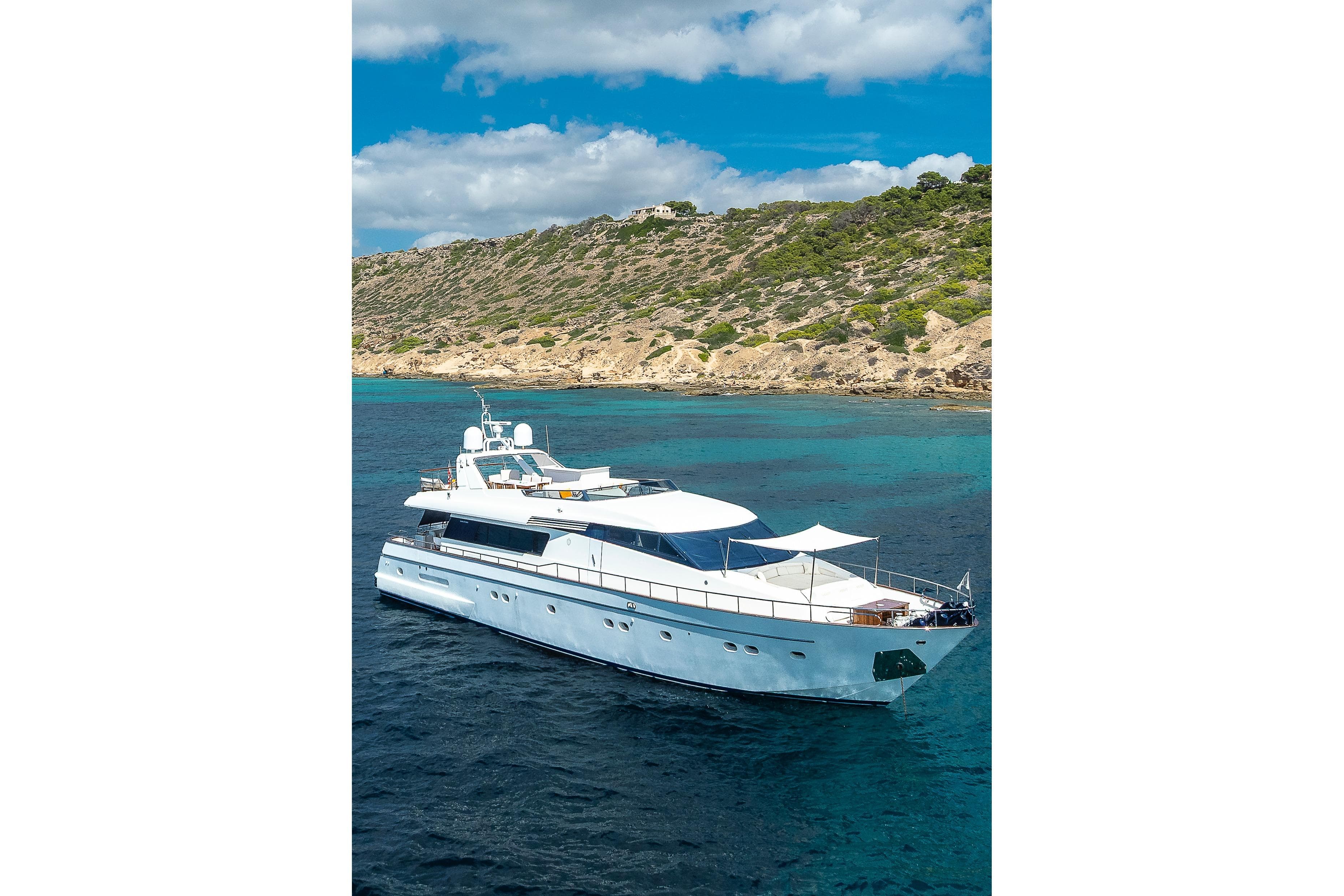 Luxurious 1997 Sanlorenzo 82 yacht cruising near scenic coastline.