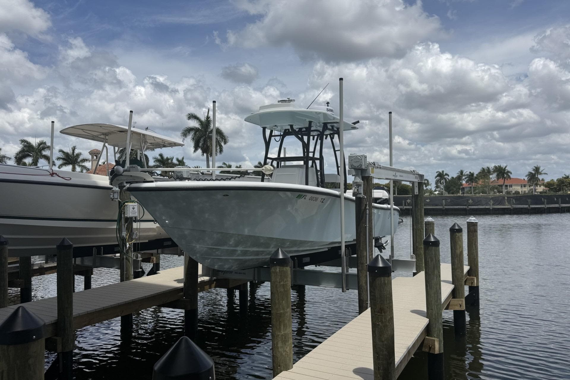 2023 Yellowfin 26 Hybrid boat docked at marina under cloudy sky.