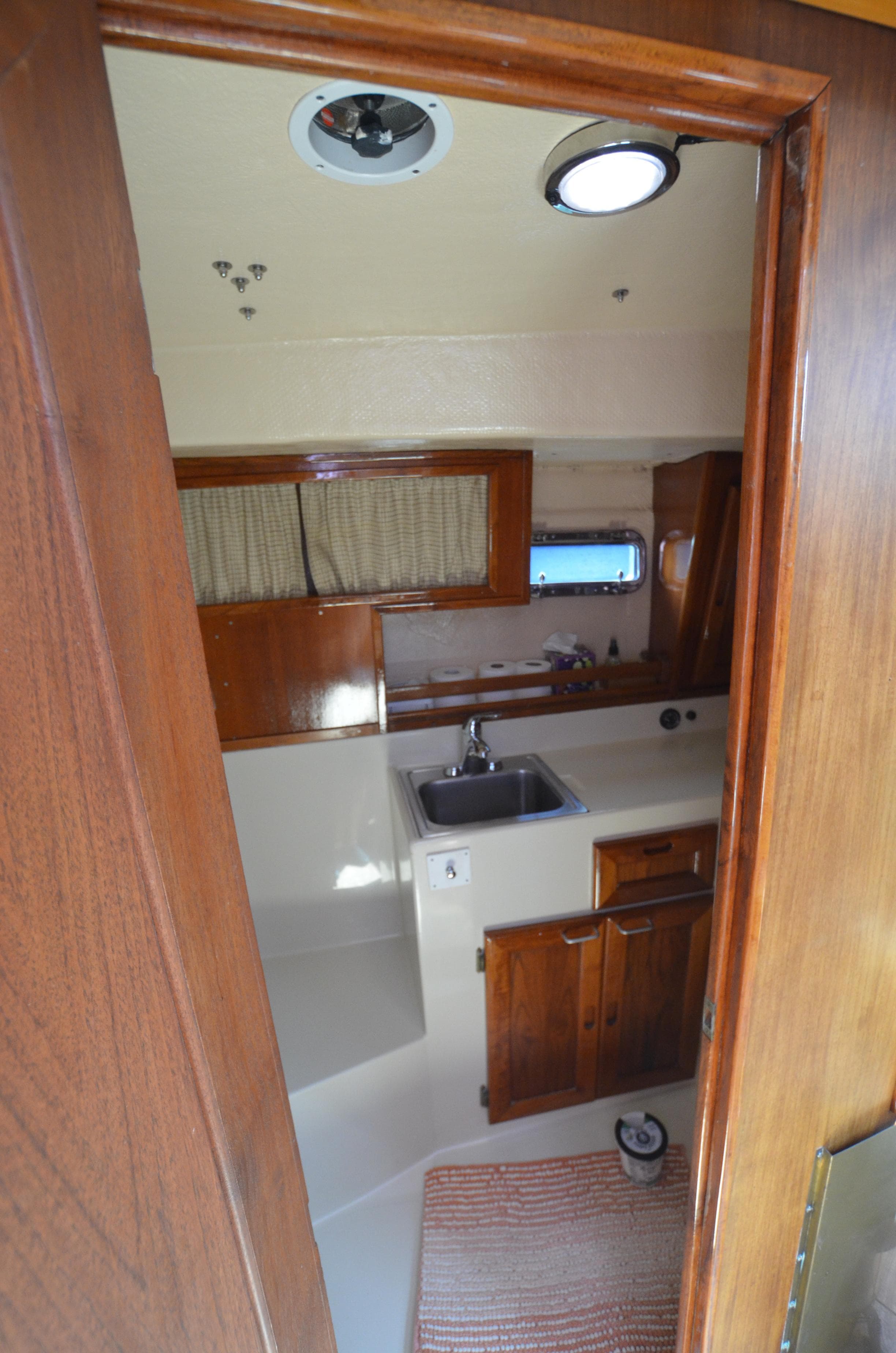 1980 Cooper 416 Pilothouse interior with wooden cabinetry and compact kitchen area.