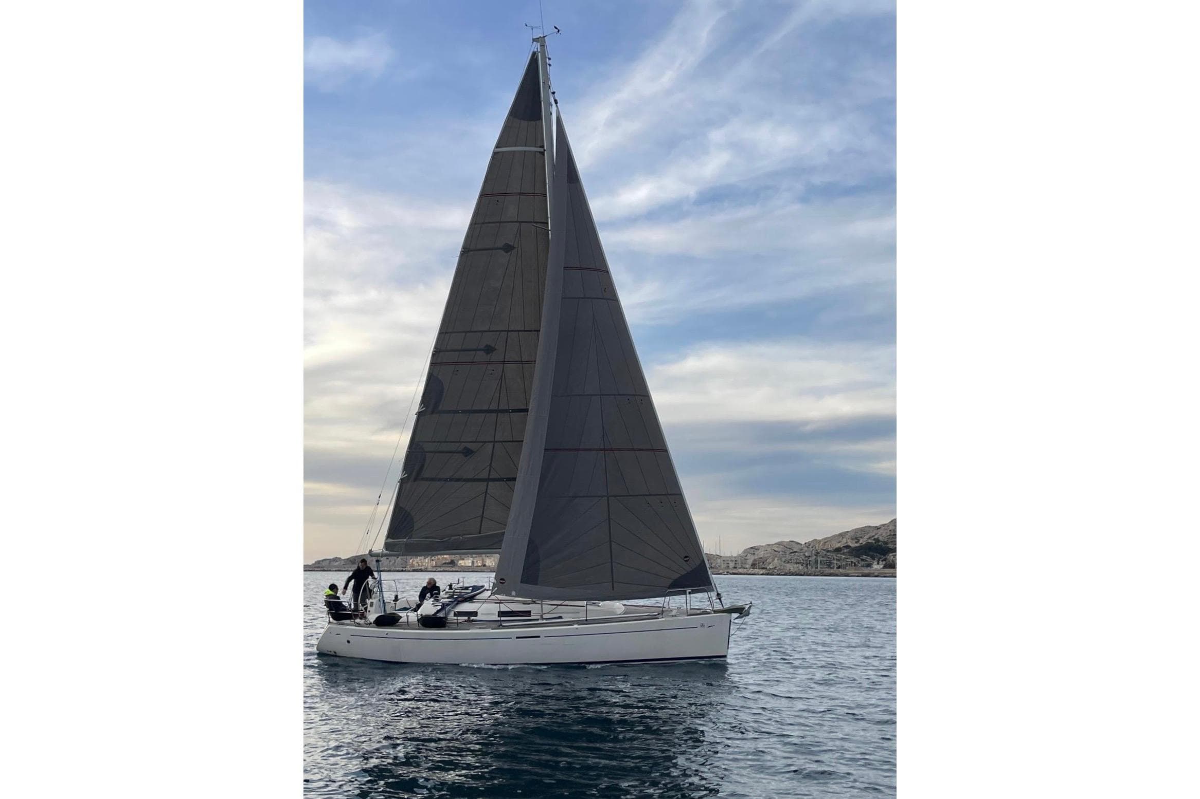 2005 Dufour 34 Performance sailboat on calm waters under a cloudy sky.