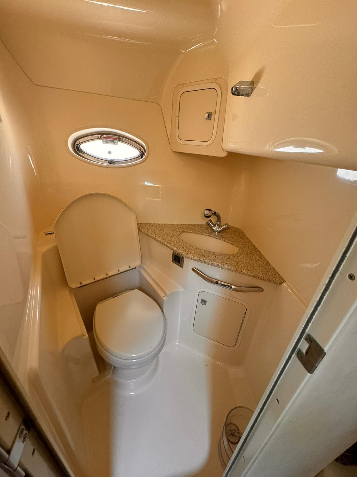 2008 Sea Ray Sundancer bathroom with compact design, featuring a toilet, sink, and small window.