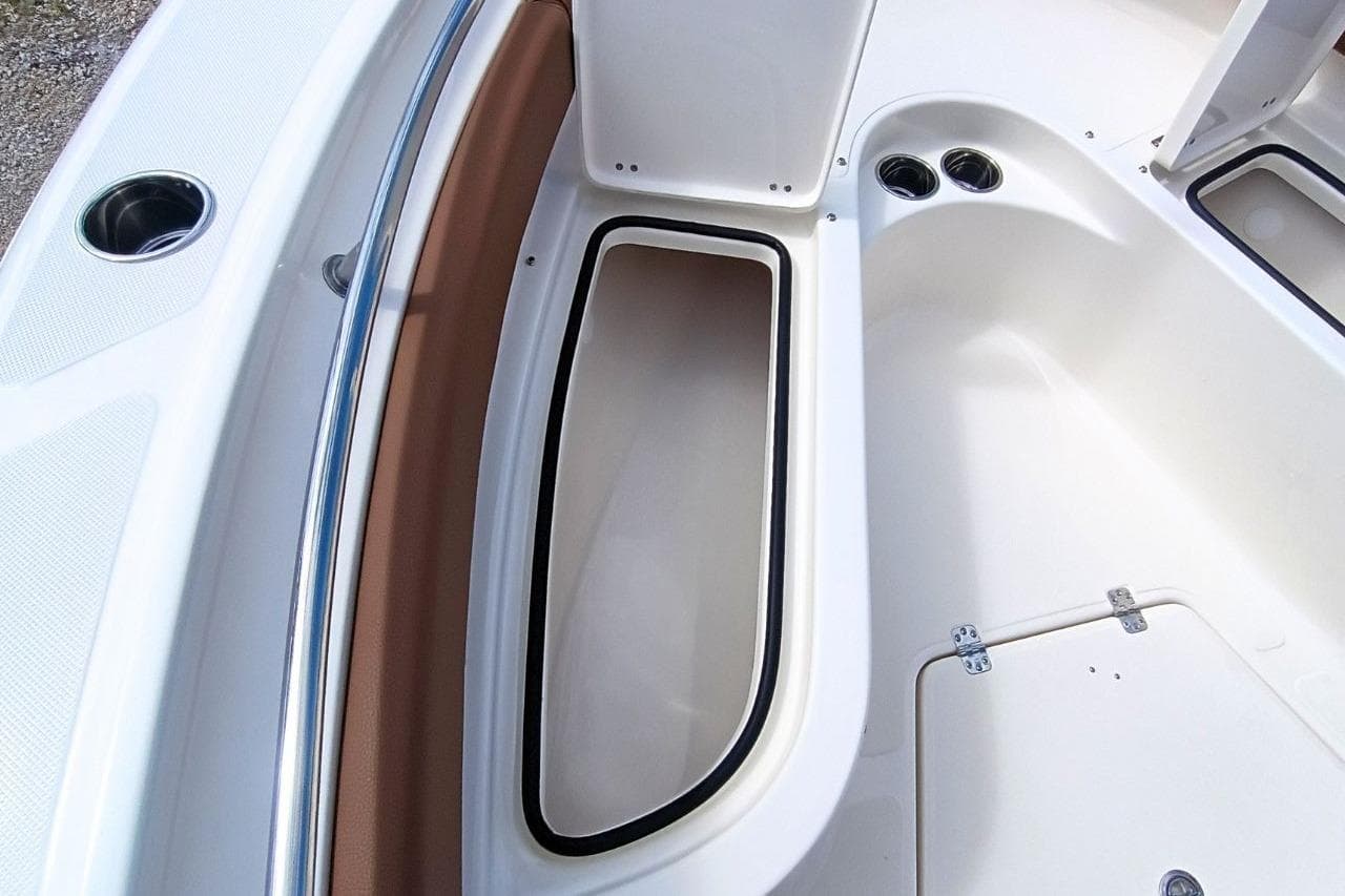 2027 Pioneer 222 Sportfish boat interior storage compartment with cup holders and sleek design.