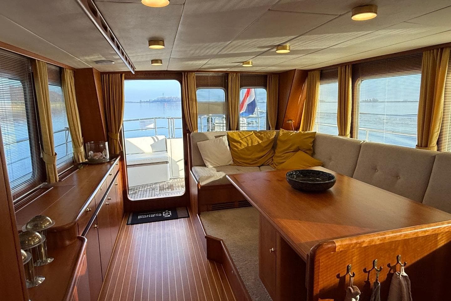 Luxurious interior of 2021 Altena Trawler 50 yacht with elegant wood finishes and cozy seating.