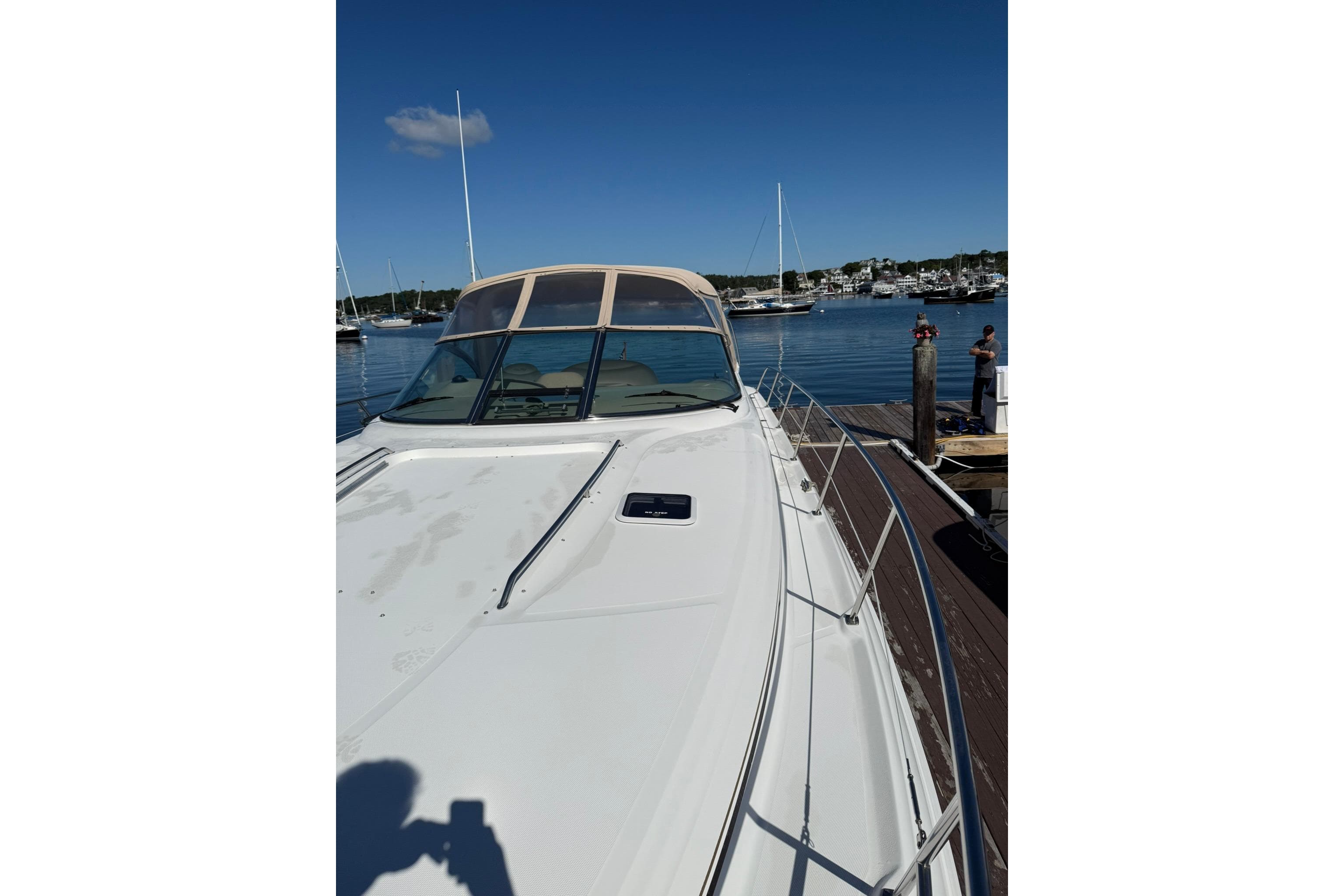2000 Sea Ray 410 Express Cruiser docked at a marina under clear blue skies.