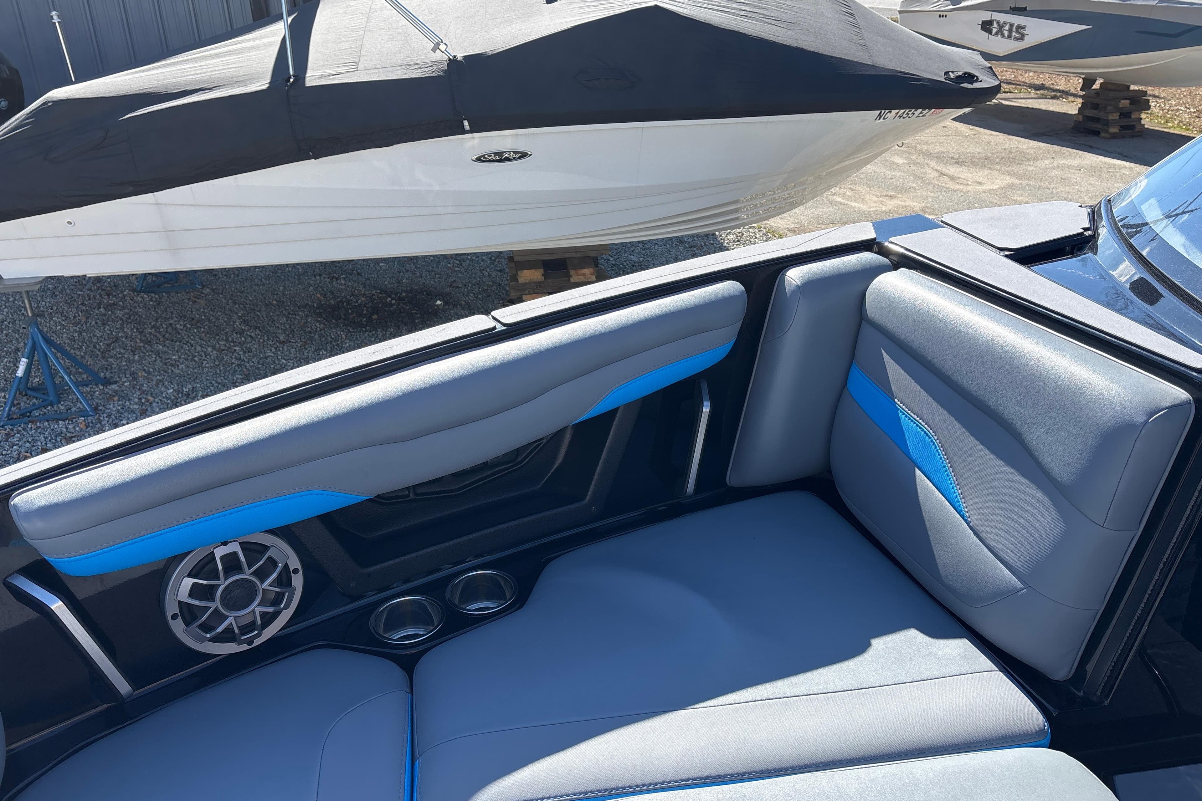 2023 Axis T220 boat interior with blue and gray seating, speaker, and cup holders.