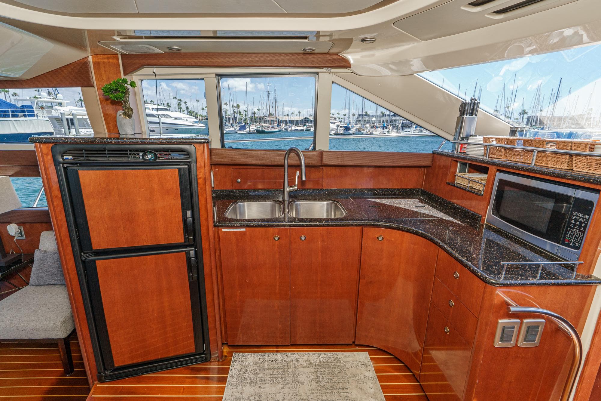 Luxurious 2009 Meridian 441 Sedan yacht kitchen with wood cabinetry and ocean view.