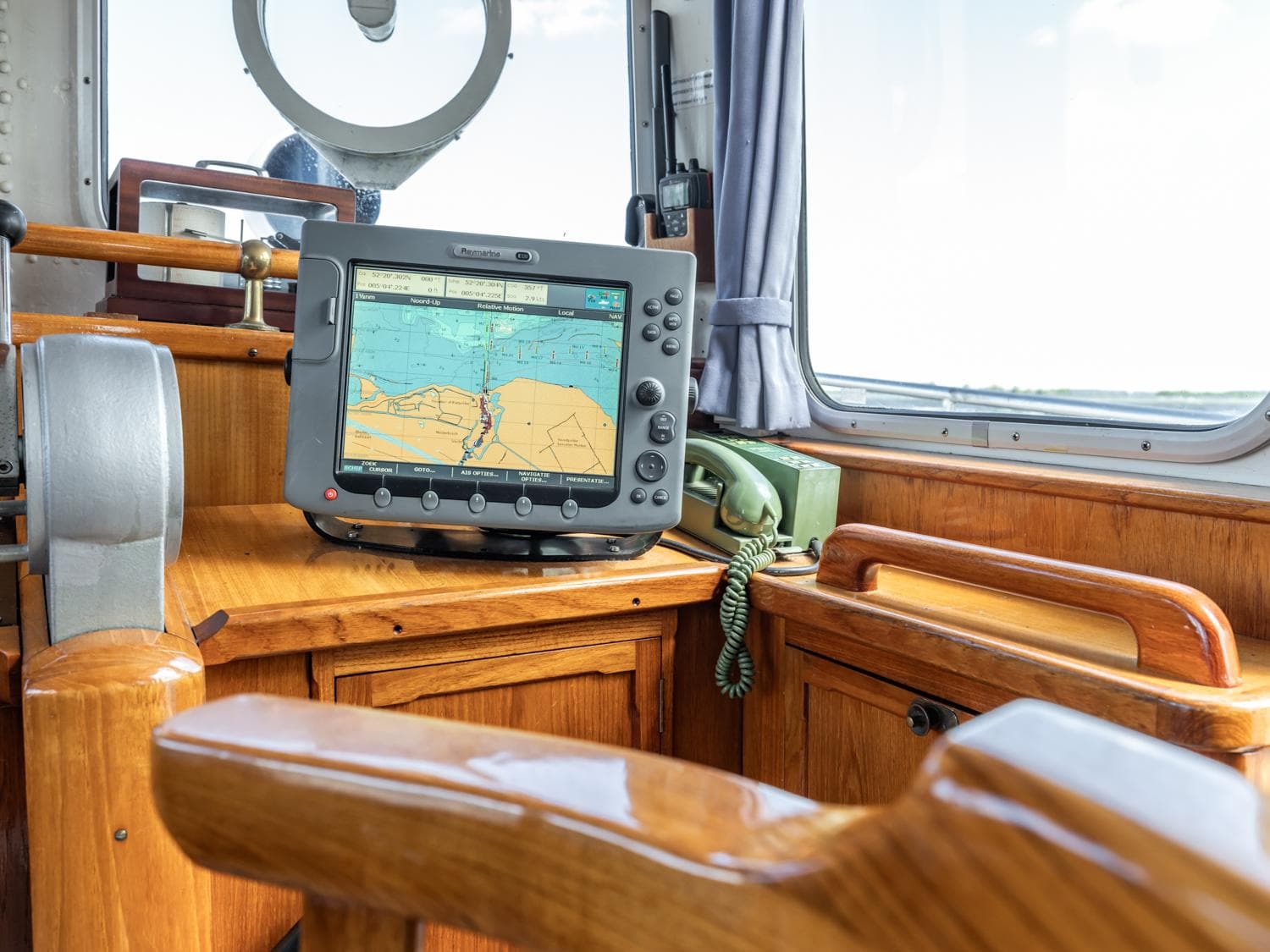1956 Motorsailer Robbenjager 16.71 cockpit with navigation system and wooden interior.