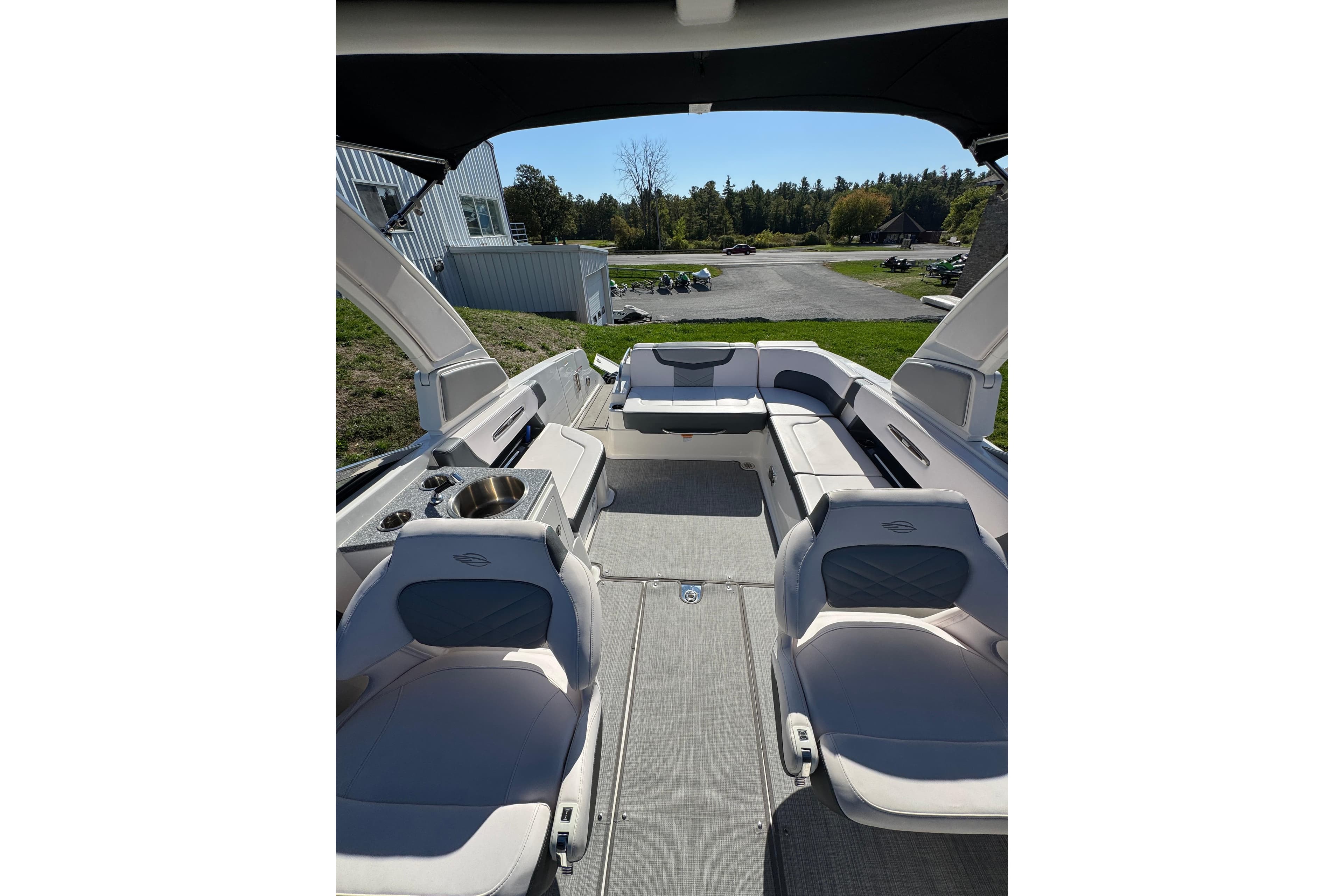 2019 Chaparral 297 SSX boat interior with seating and sink, outdoor setting.