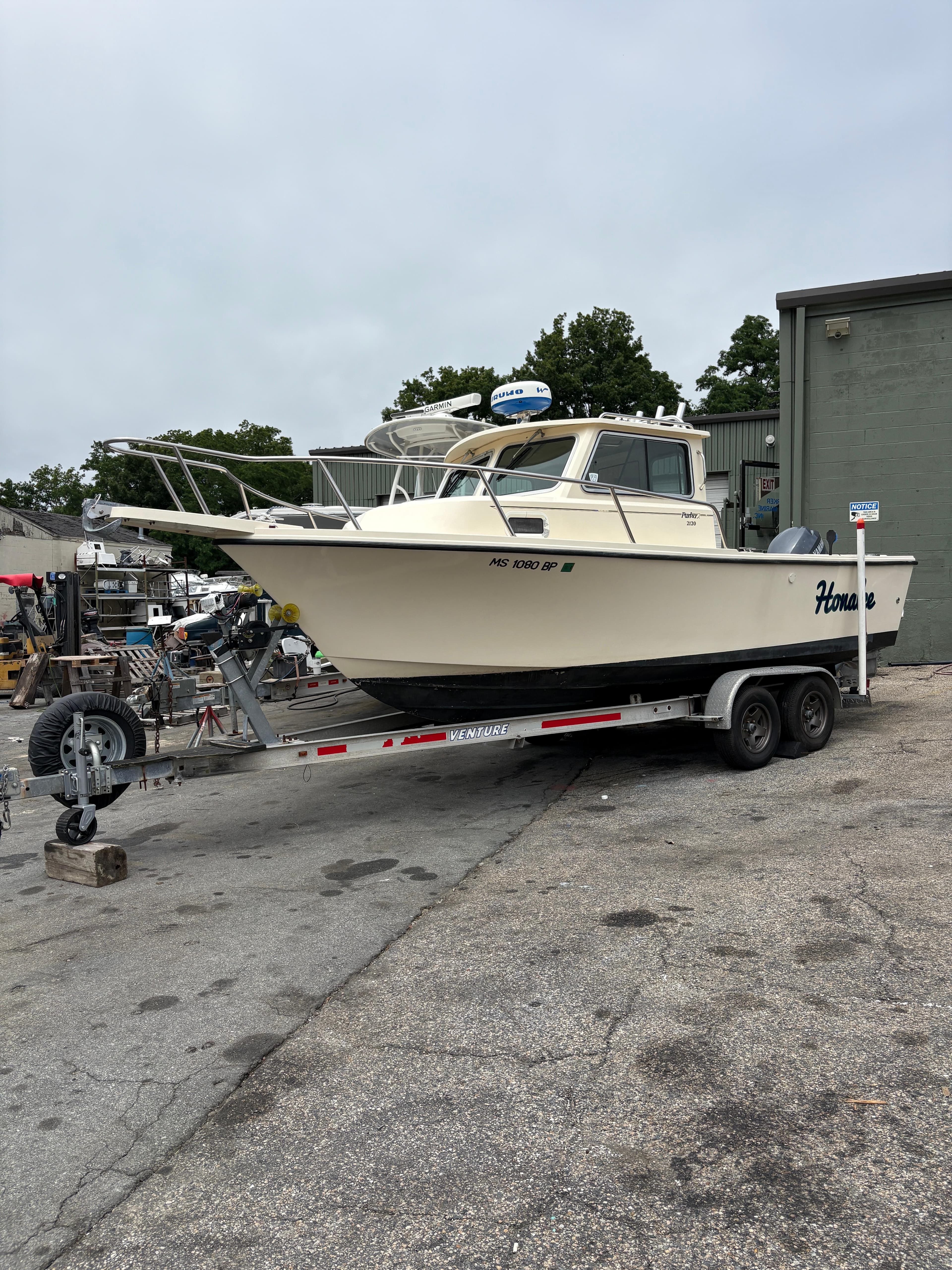 2012 Parker 2120 Sport Cabin boat on trailer in outdoor setting.