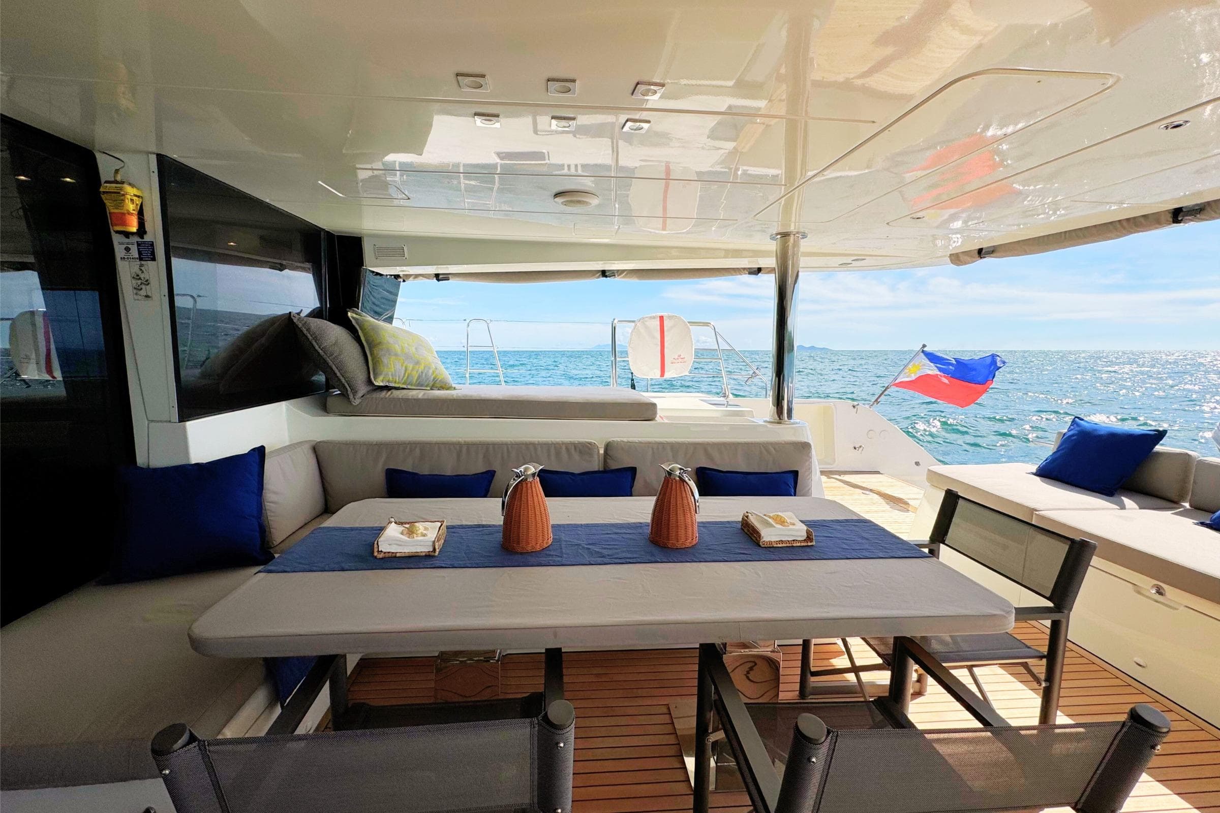 Luxurious Lagoon 620 yacht deck with dining area, ocean view, and comfortable seating, 2015 model.