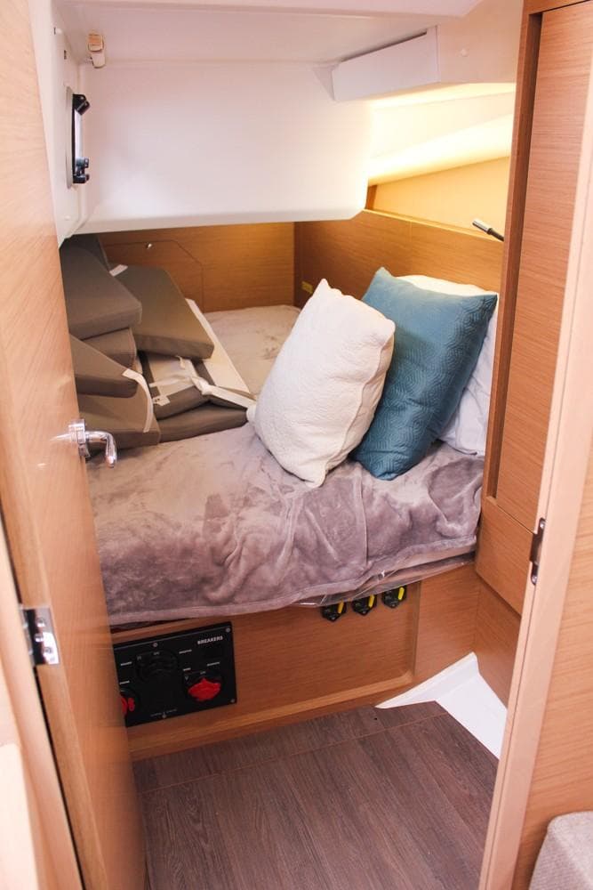 Cozy cabin interior of 2025 Jeanneau Sun Odyssey 440 sailboat with plush bedding.