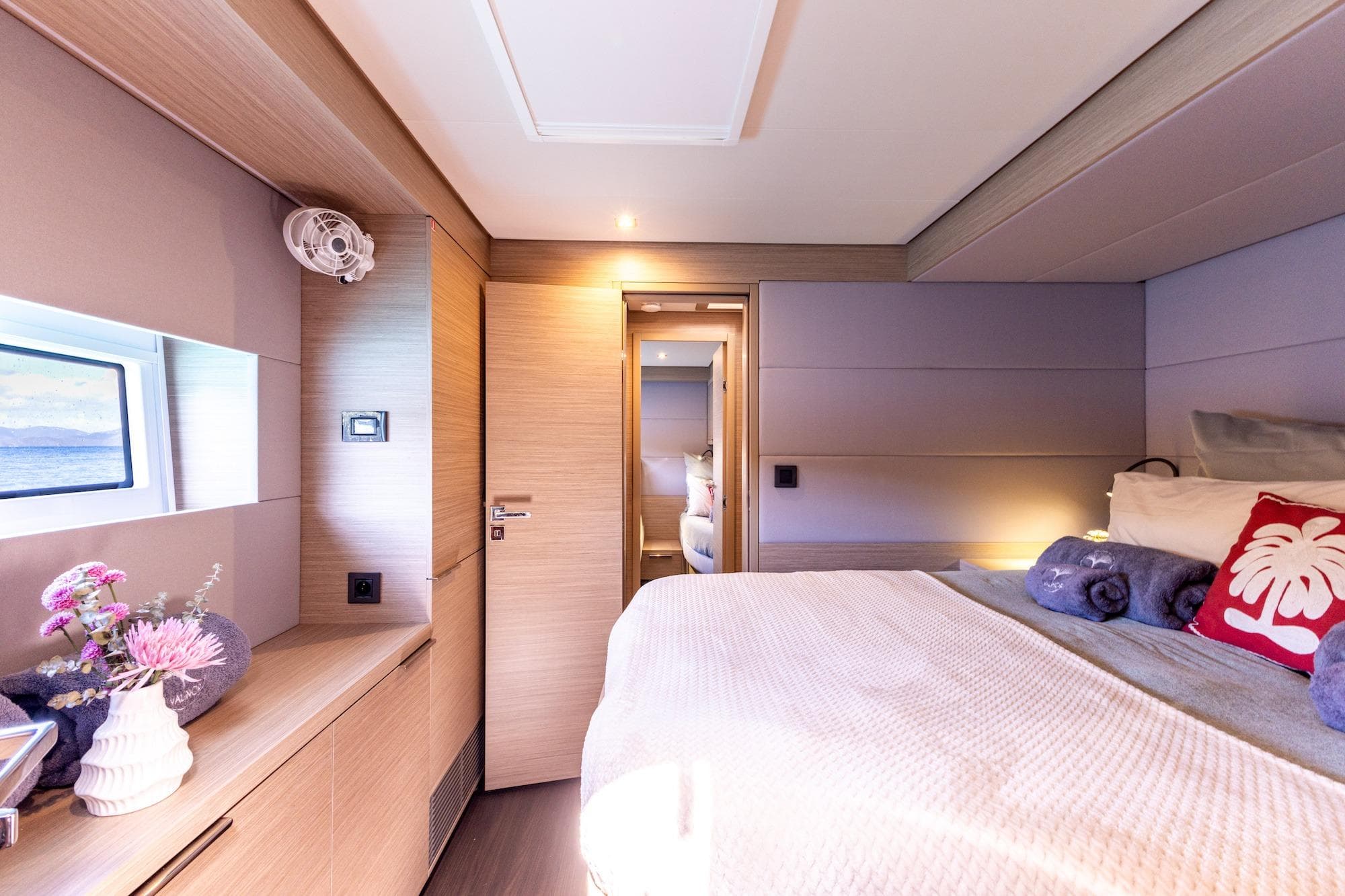 Luxurious interior of 2023 Lagoon 55 yacht cabin with modern decor and cozy bedding.