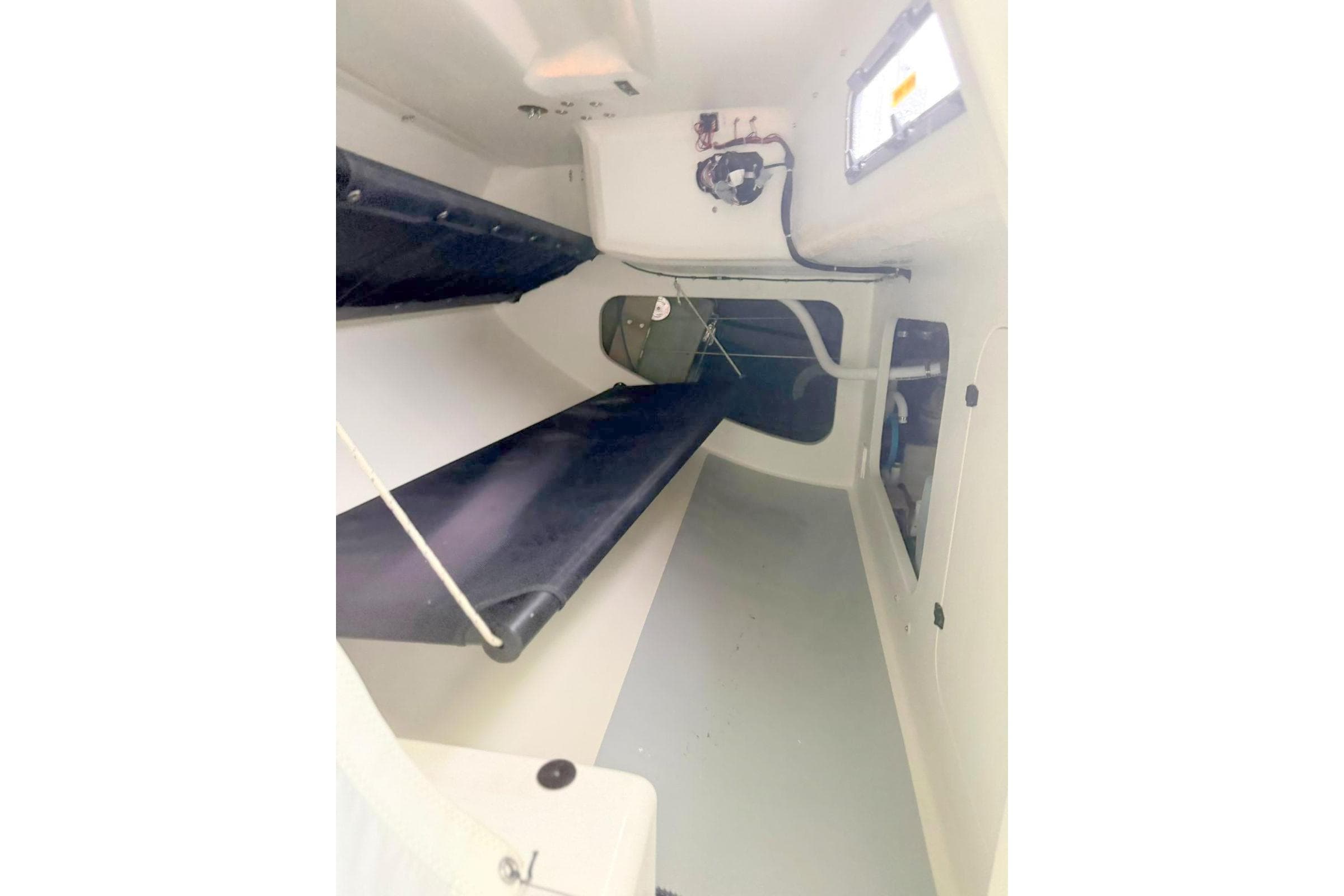 Interior of 2024 MAT 1220 sailboat, featuring compact sleeping quarters and minimalistic design.