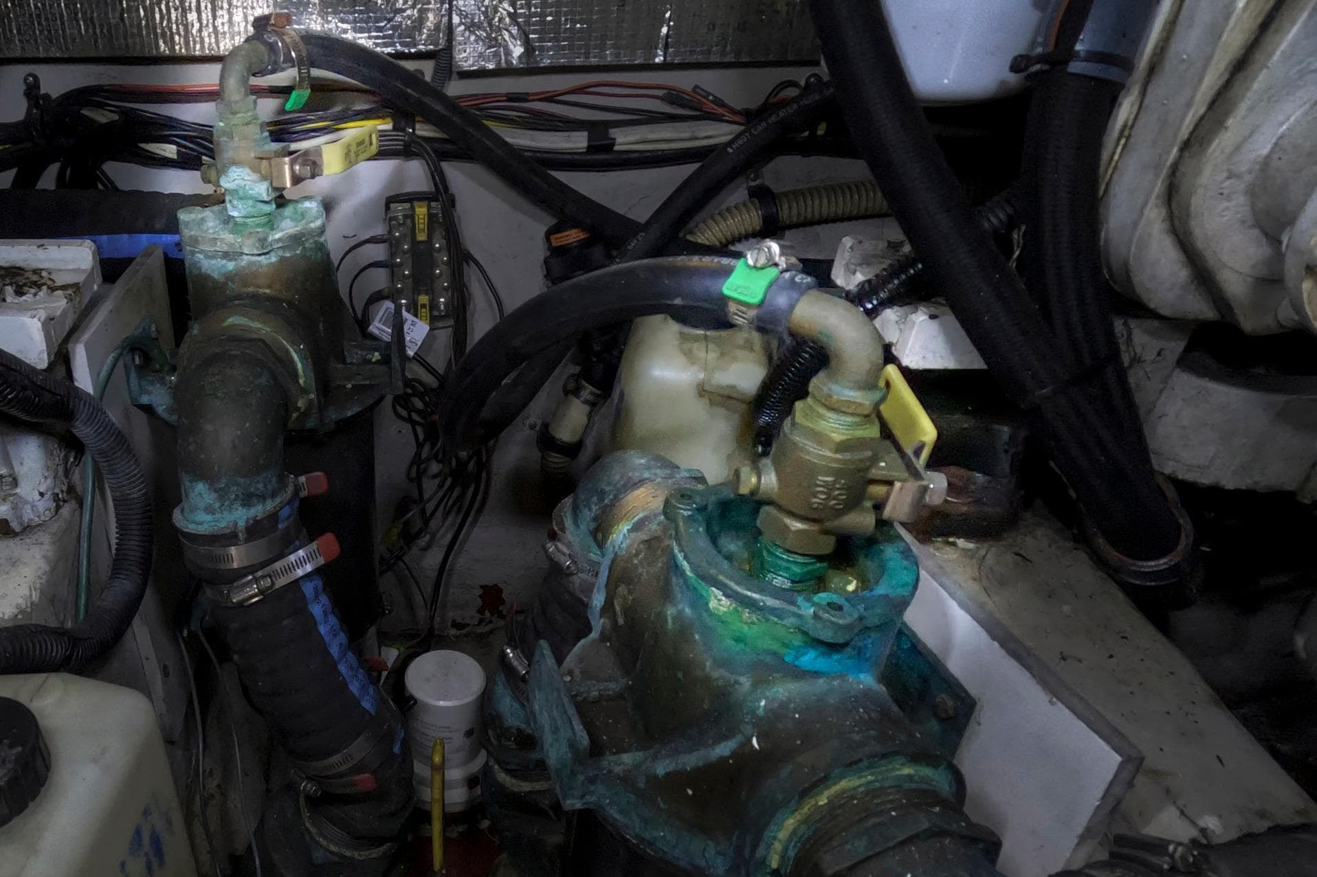 Engine room of 2007 Sea Ray 44 Sedan Bridge with corroded valves and pipes.