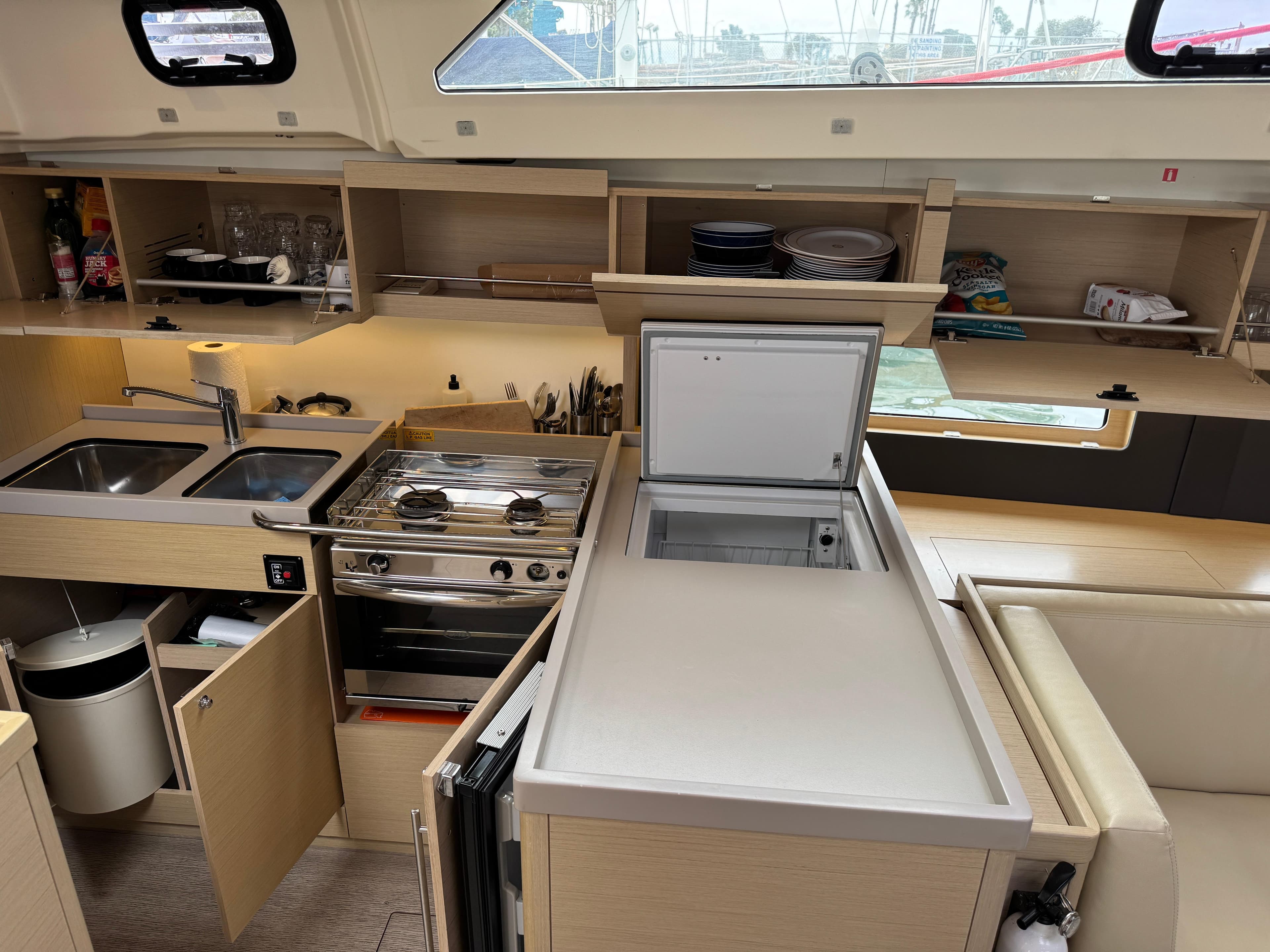 Modern kitchen interior of 2021 Beneteau Oceanis 46.1 yacht with appliances and storage.