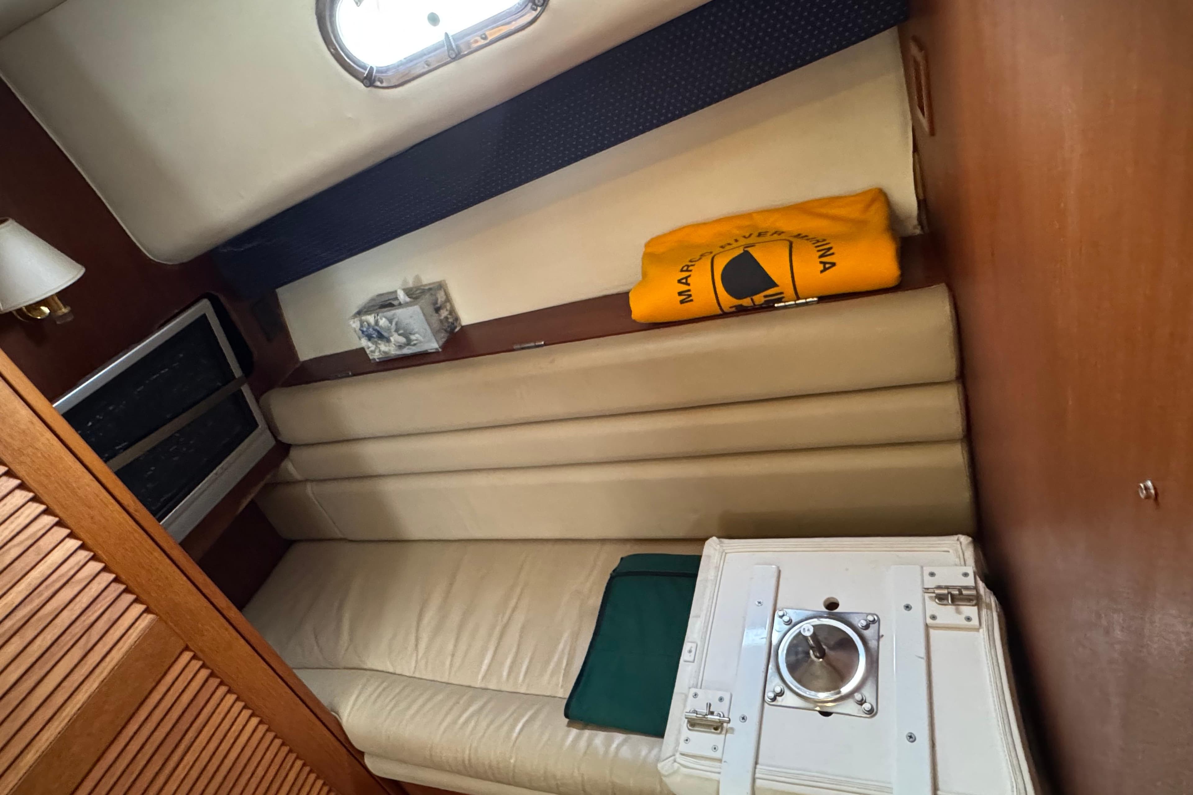 Interior cabin of a 2002 Pursuit 3800 Express boat with beige seating and wooden accents.