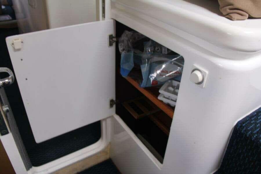 Open storage compartment on 1995 Voyage Yachts Mayotte, showing interior shelves and contents.