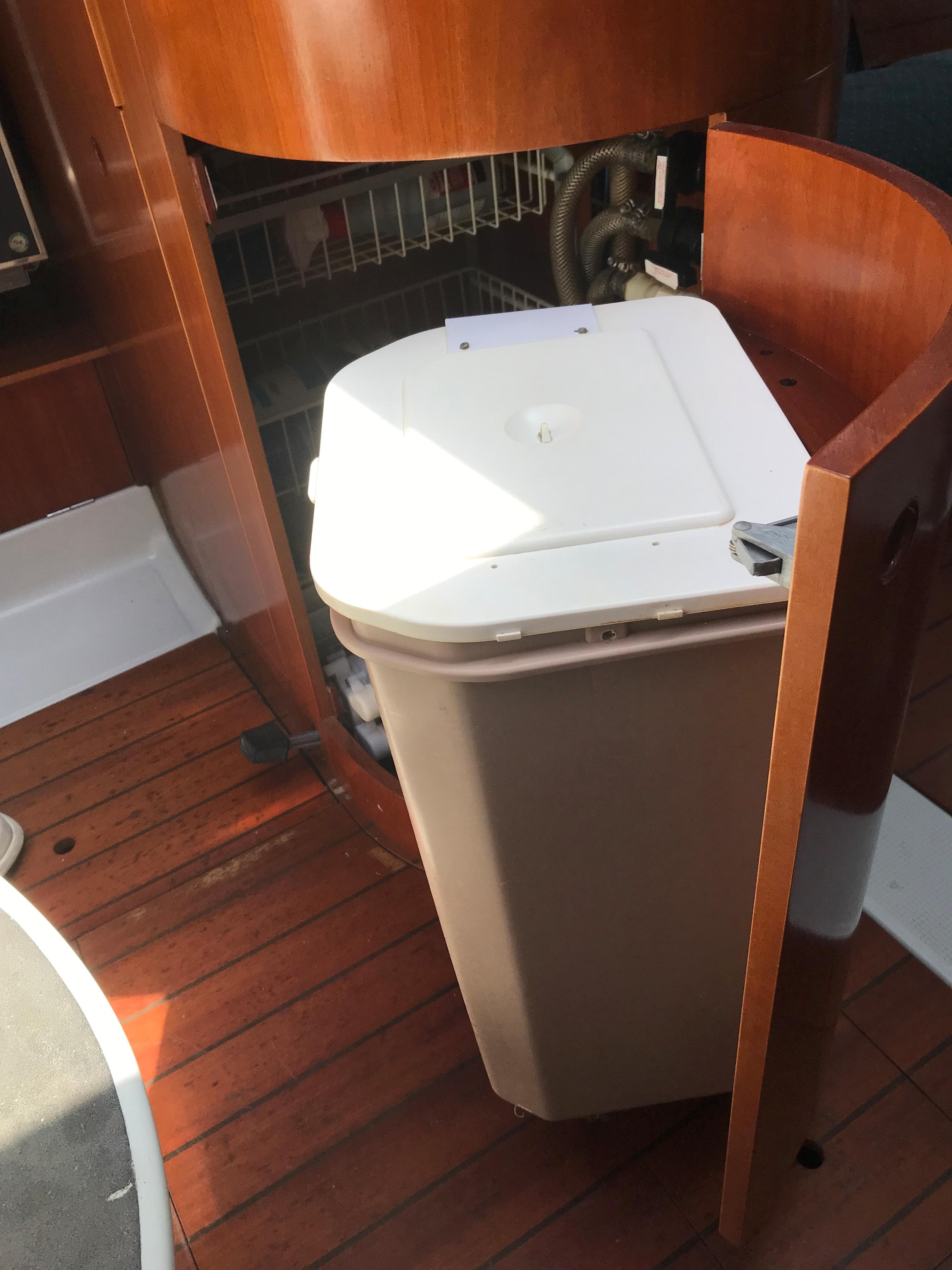 Interior of 1993 Beneteau First 310 sailboat with wooden flooring and storage compartment.