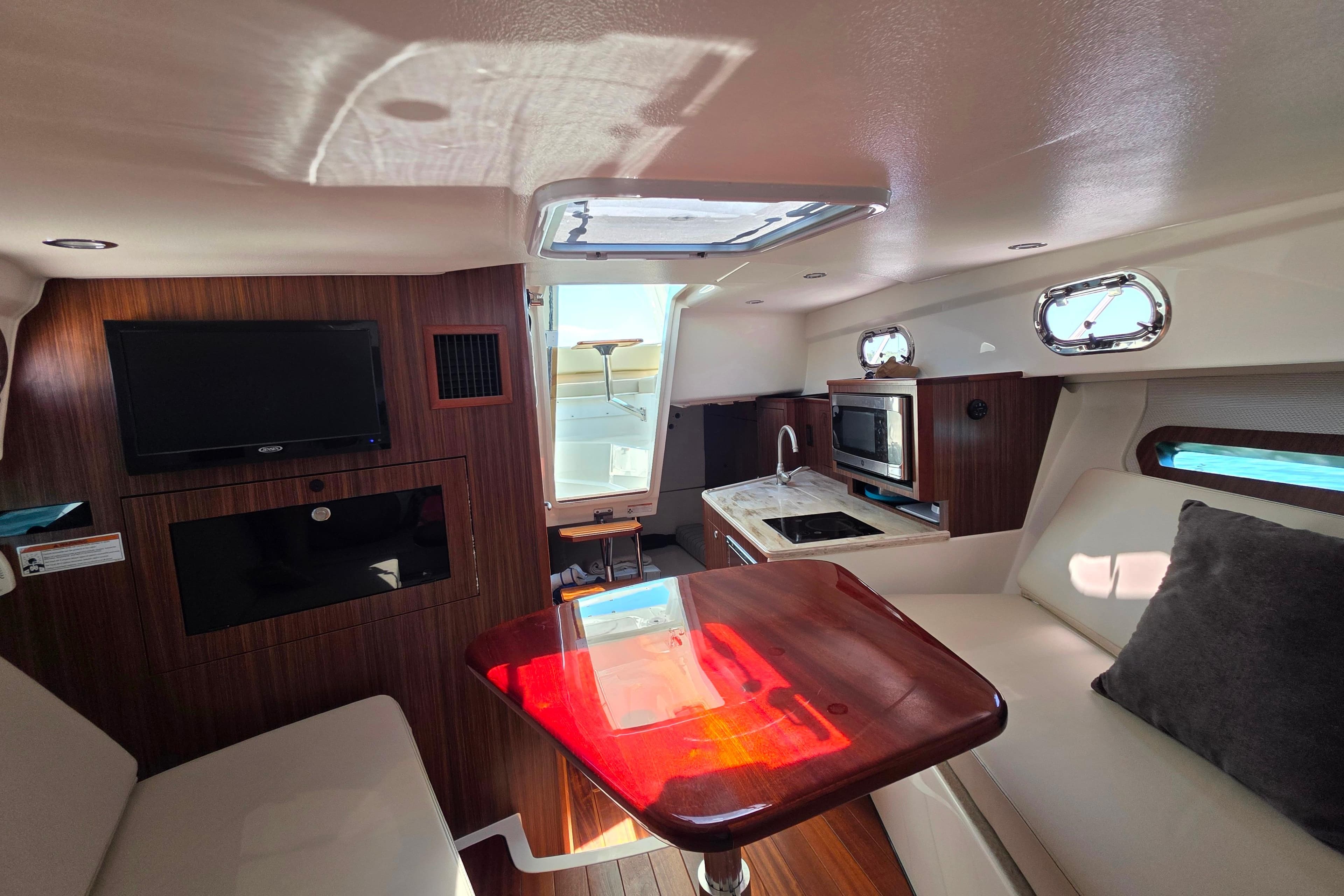 Interior of 2020 Pursuit OS 325 Offshore boat with kitchenette and seating area.