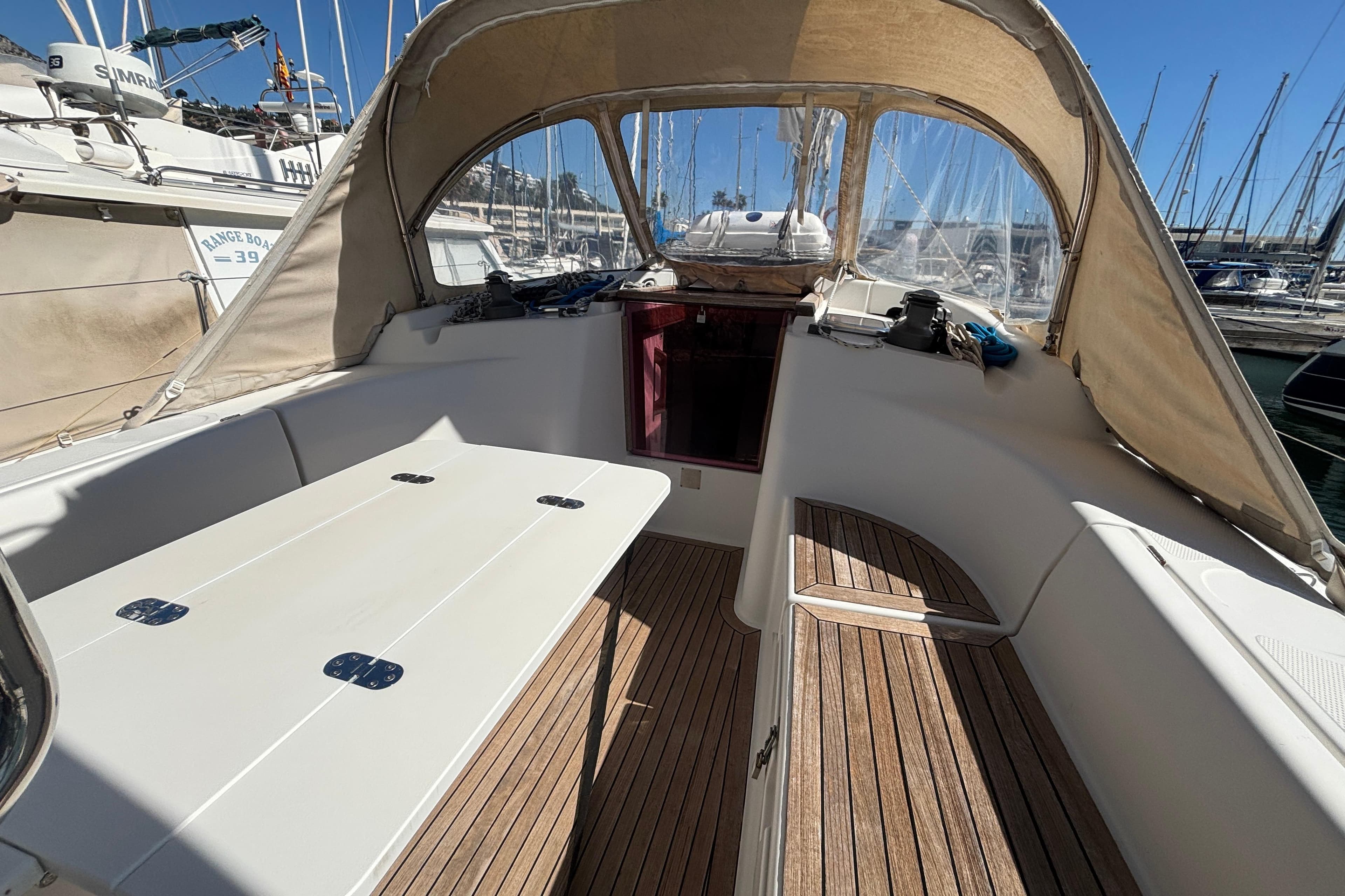 Cockpit of 2008 Hanse 370 sailboat with wooden flooring and canopy in marina.