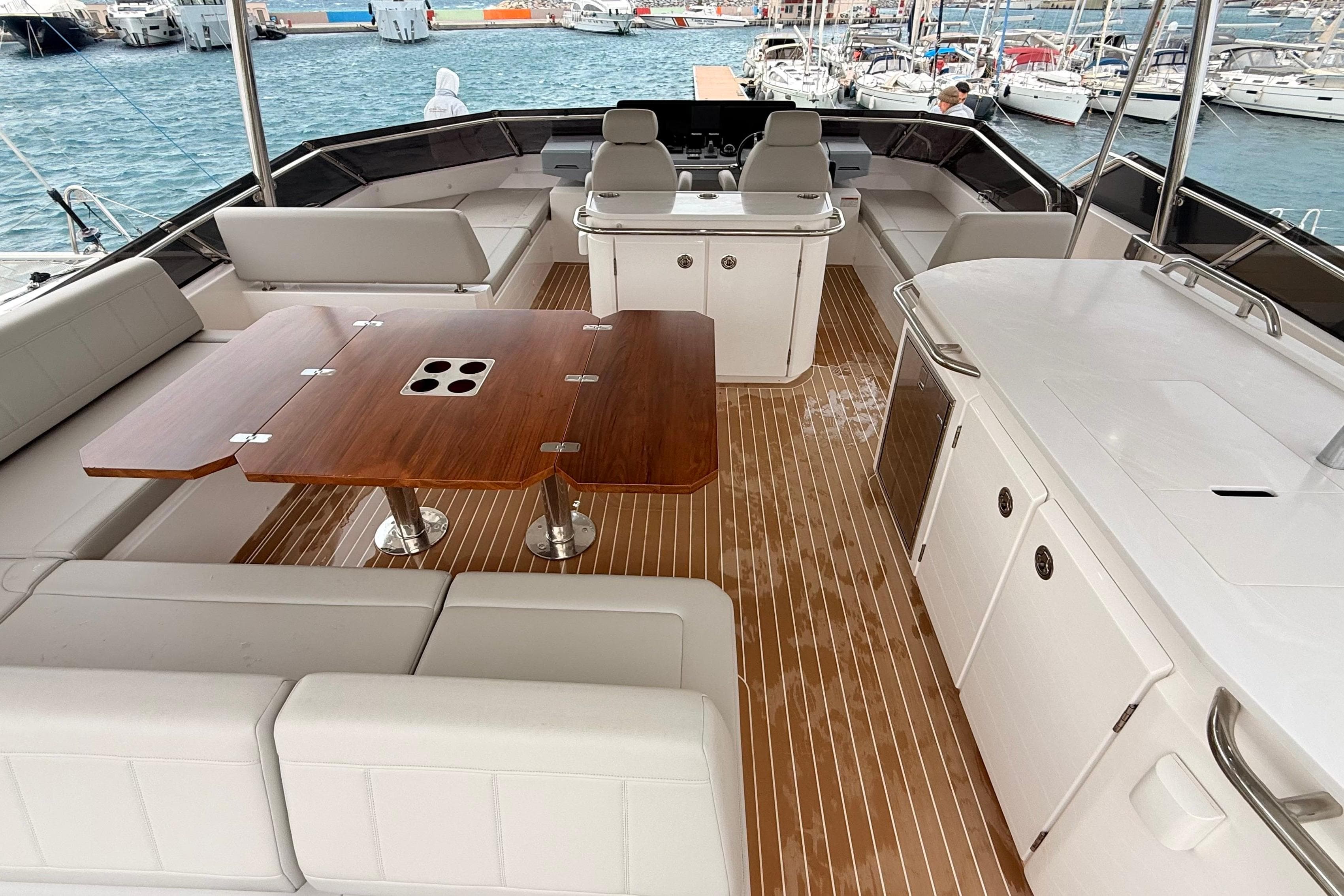 Luxurious 2025 Aquila 50 Yacht interior with elegant seating and wooden table.