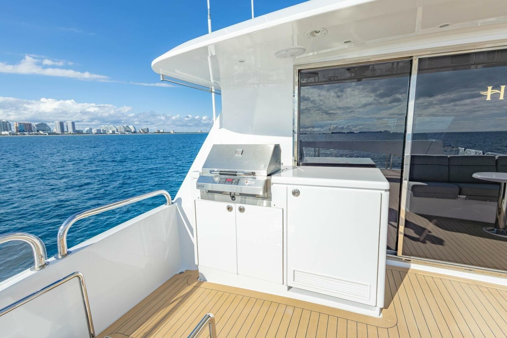 2009 Hargrave Enclosed Bridge yacht deck with grill, ocean view, and city skyline.