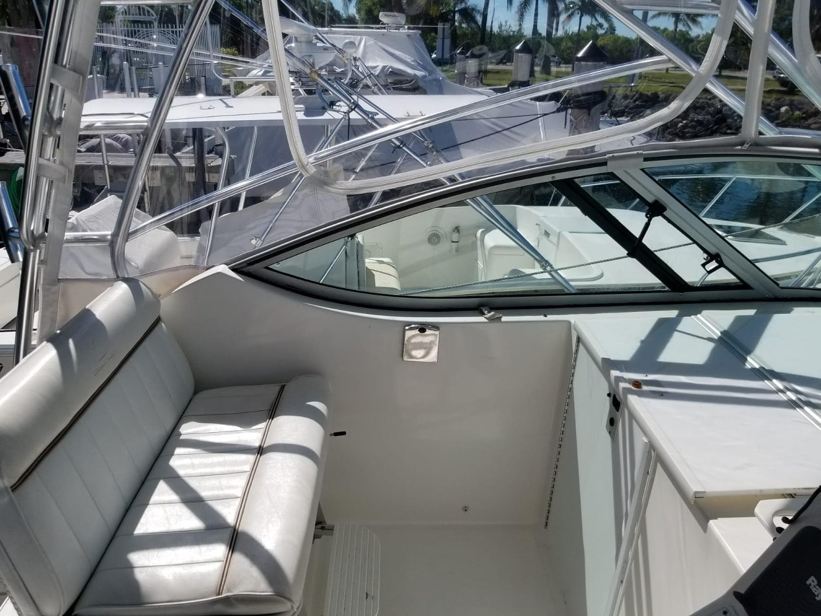 2006 Stamas 320 Express boat interior with white seating and clear canopy.