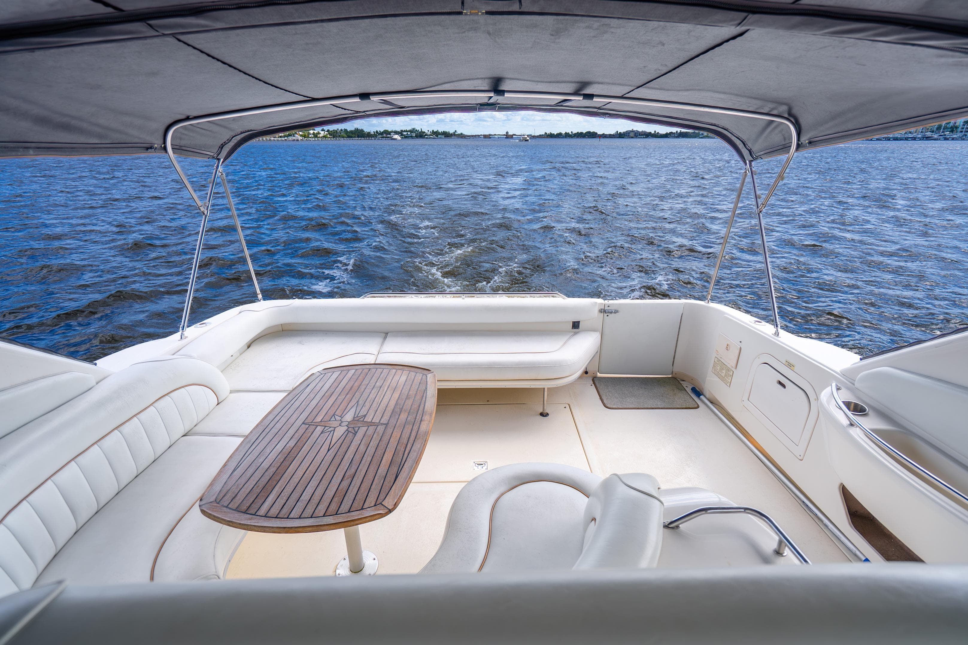 1998 Sea Ray 450 Sundancer yacht interior with seating and table, overlooking the water.