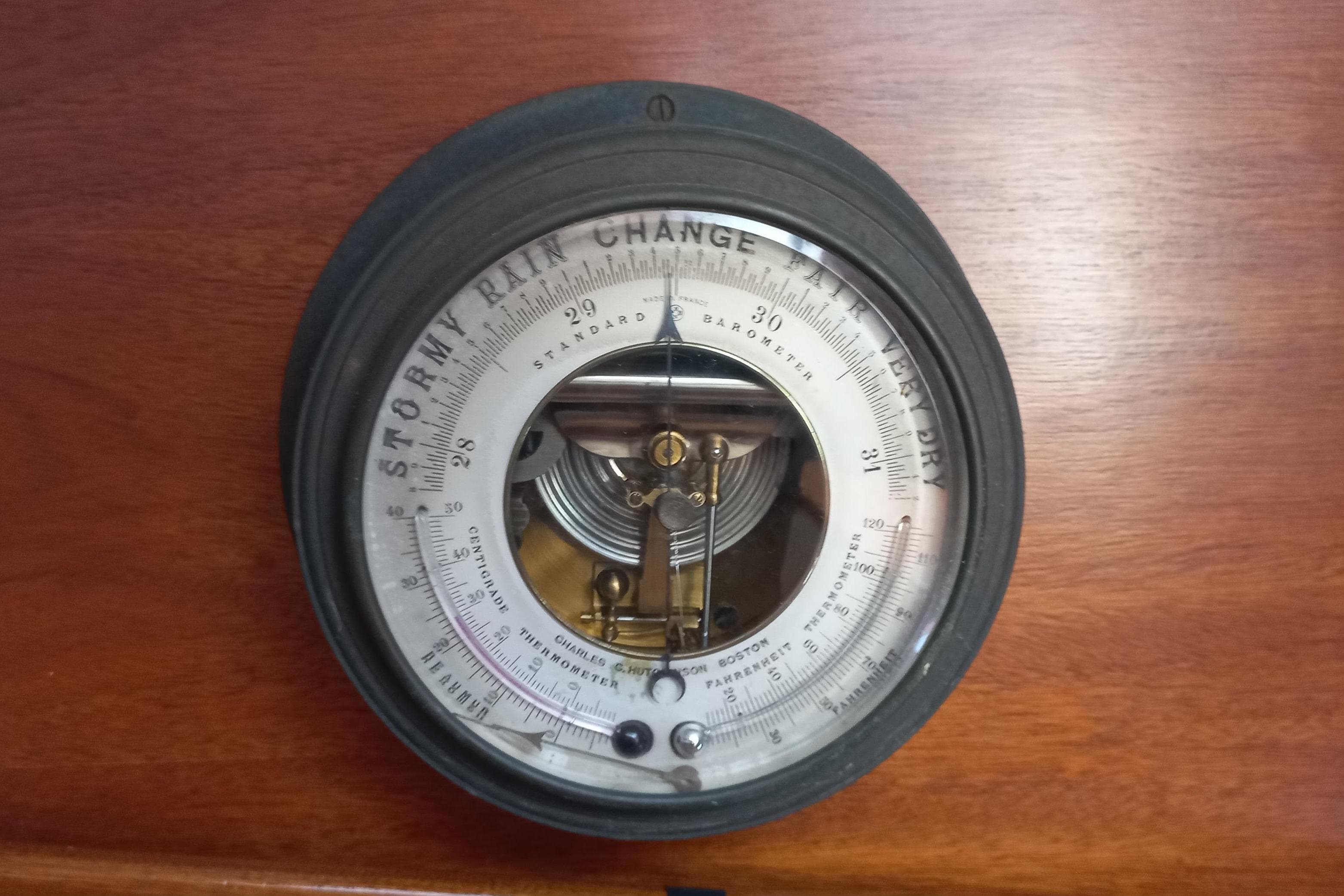 Vintage barometer on 1974 Hinckley 49 yacht, displaying weather conditions.