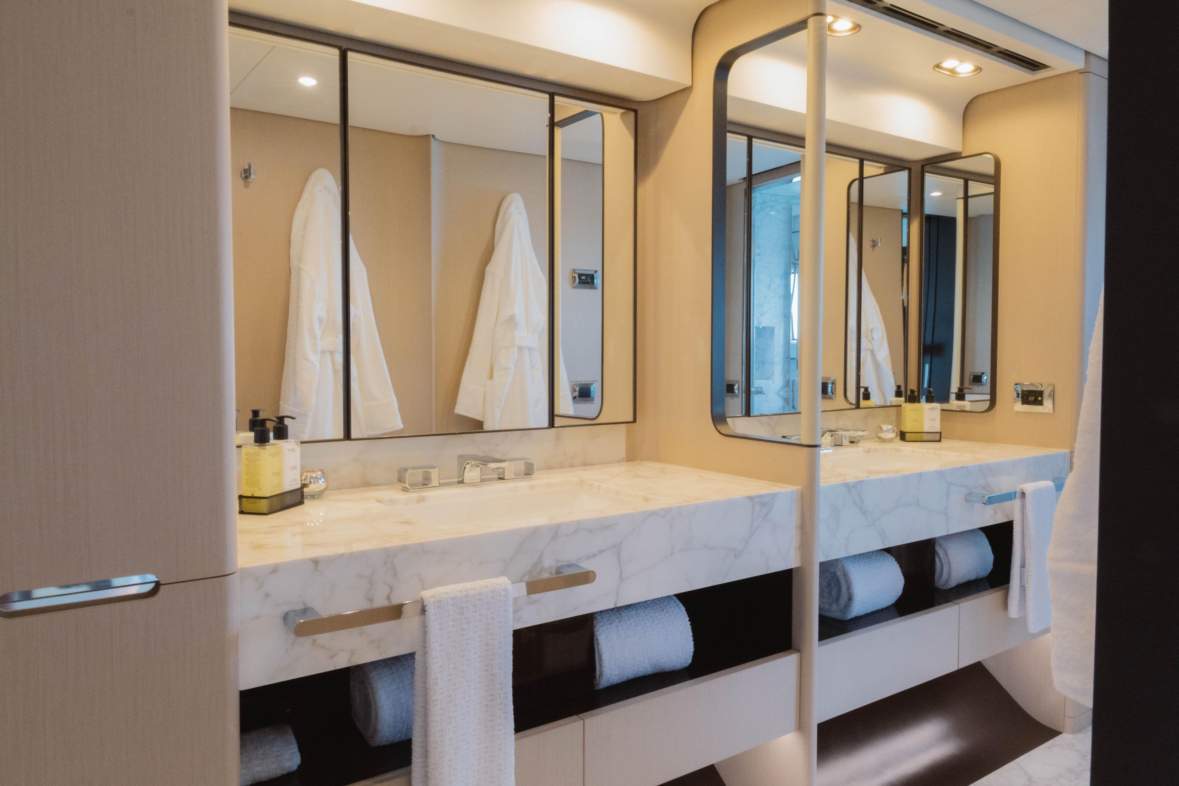 Luxurious bathroom in 2023 Azimut 32M Grande yacht with marble countertops and modern mirrors.