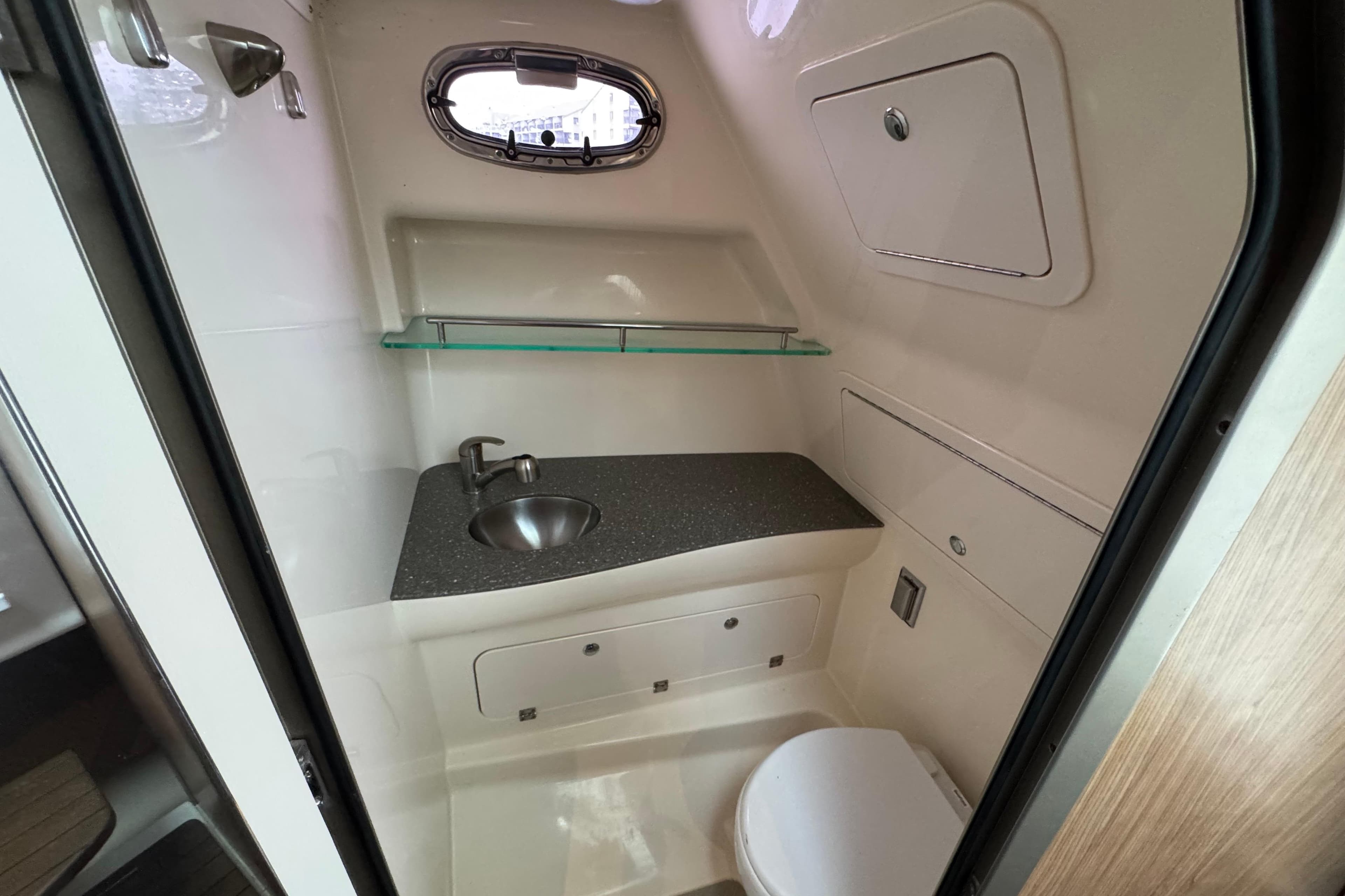 2016 Boston Whaler 315 Conquest bathroom with sink, toilet, and storage.