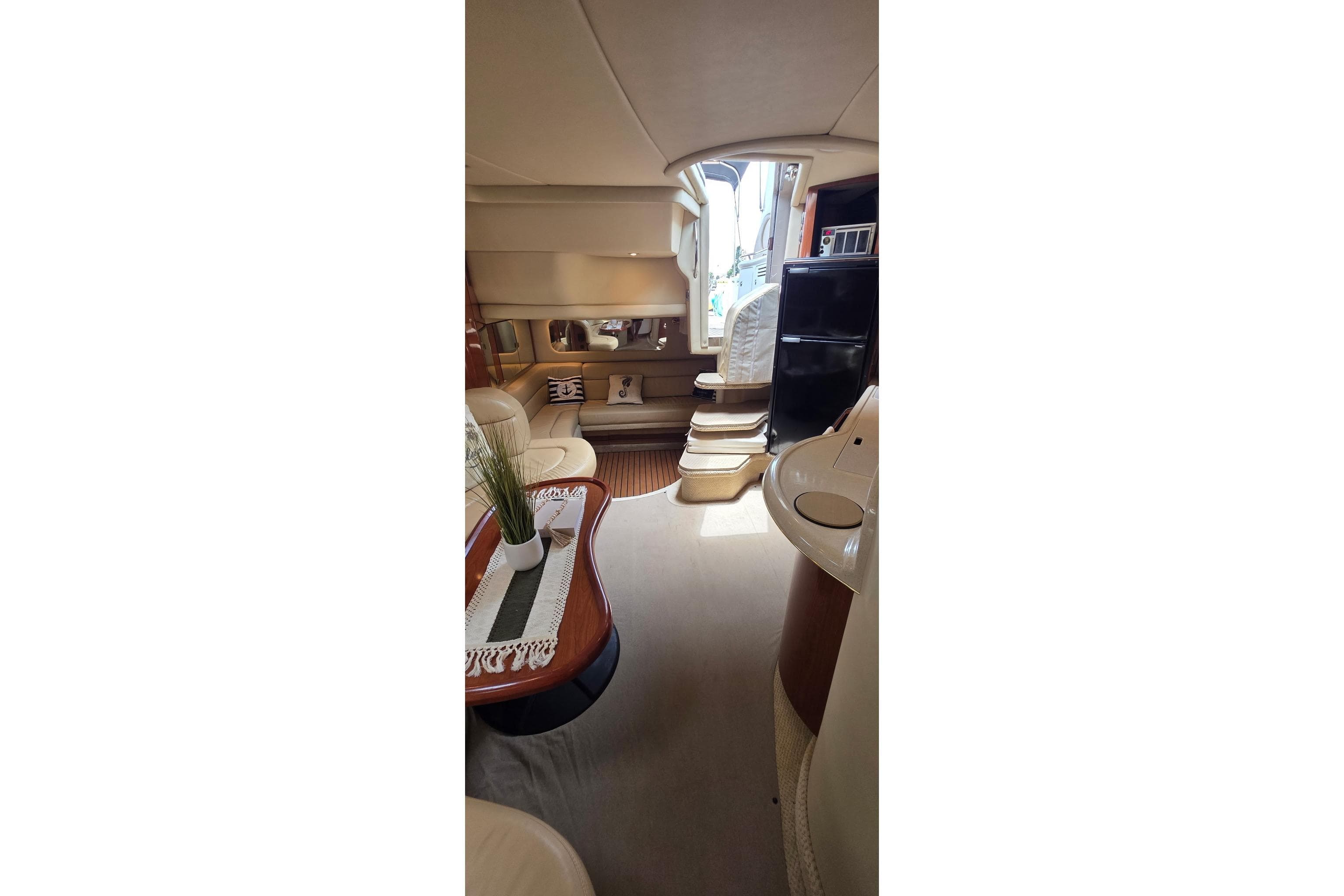 Interior of 2002 Sea Ray 380 Sundancer yacht, featuring elegant seating and modern amenities.