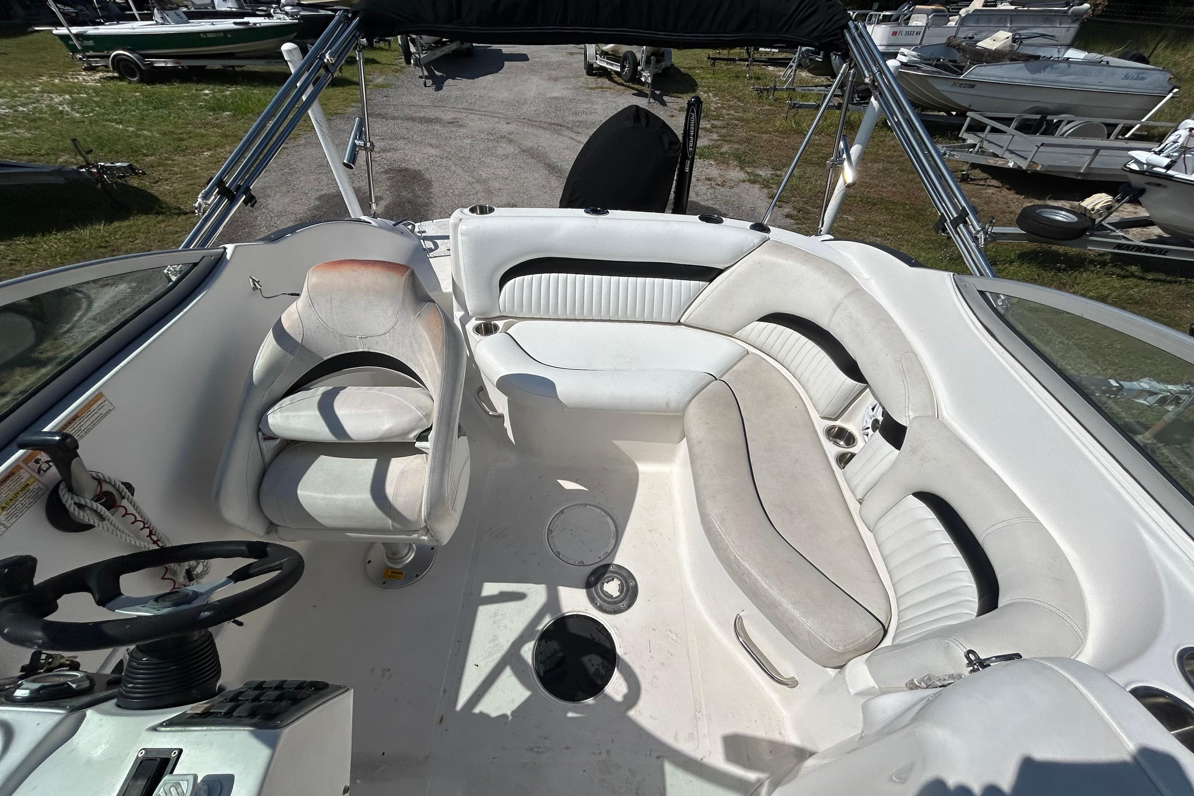 2011 Hurricane SunDeck 2000 OB boat interior with white seating and steering console.