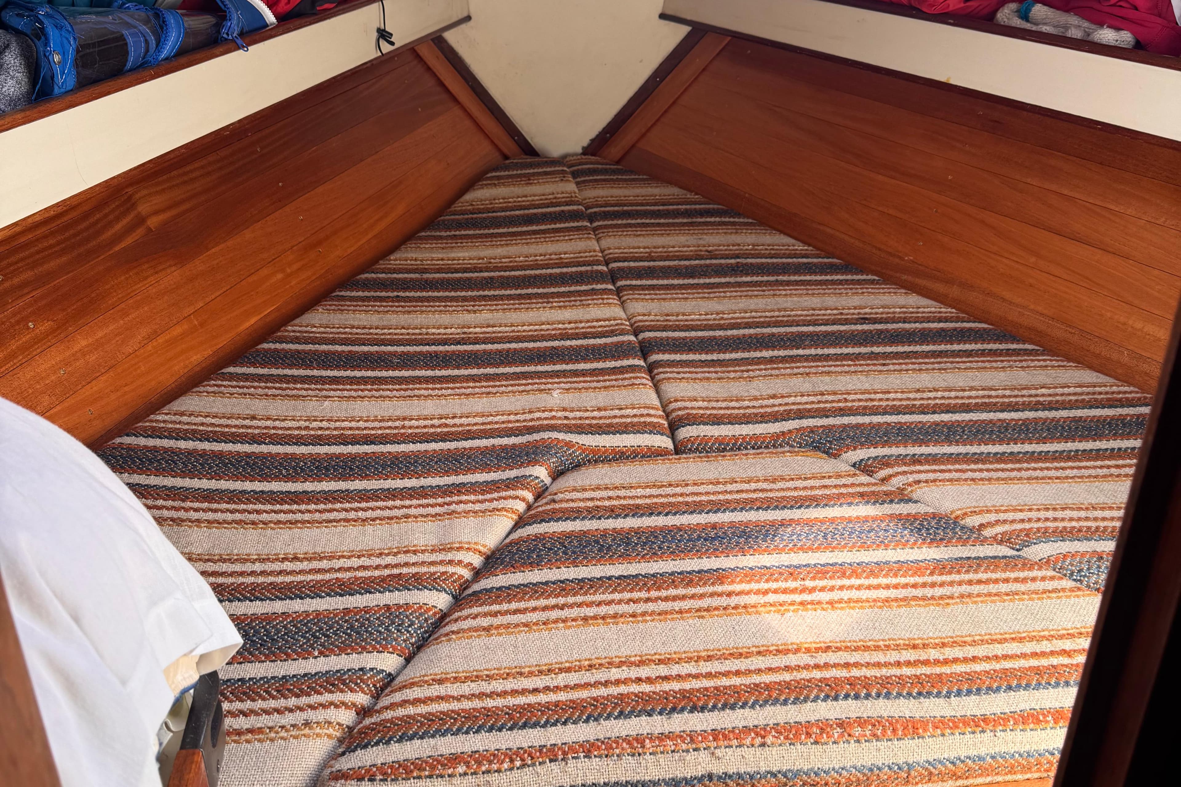 Cozy cabin interior of 1983 C&C 32 sailboat with striped cushions.
