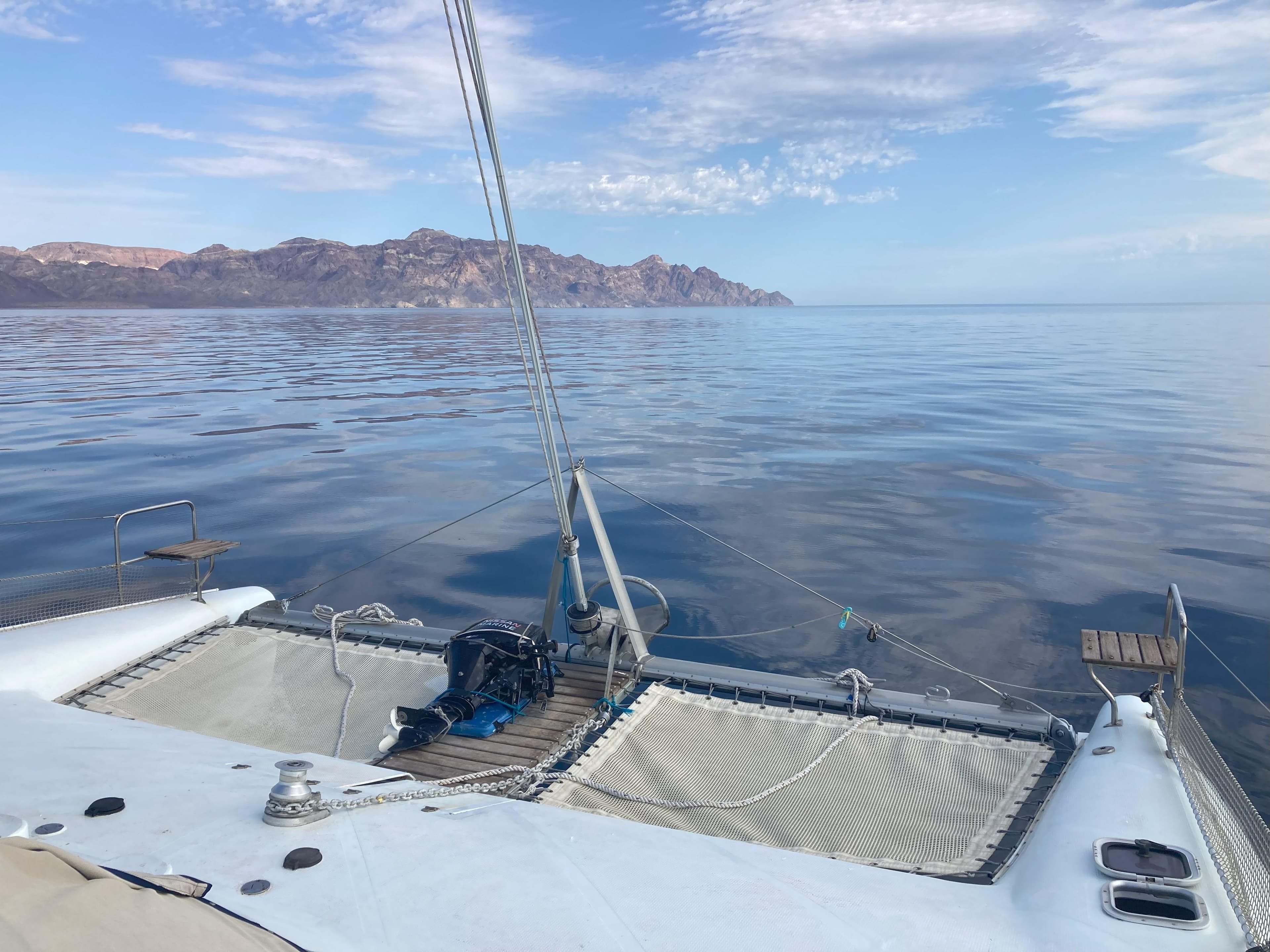 Sailing on a 2002 Wildcat MKIII catamaran with scenic mountain and ocean views.