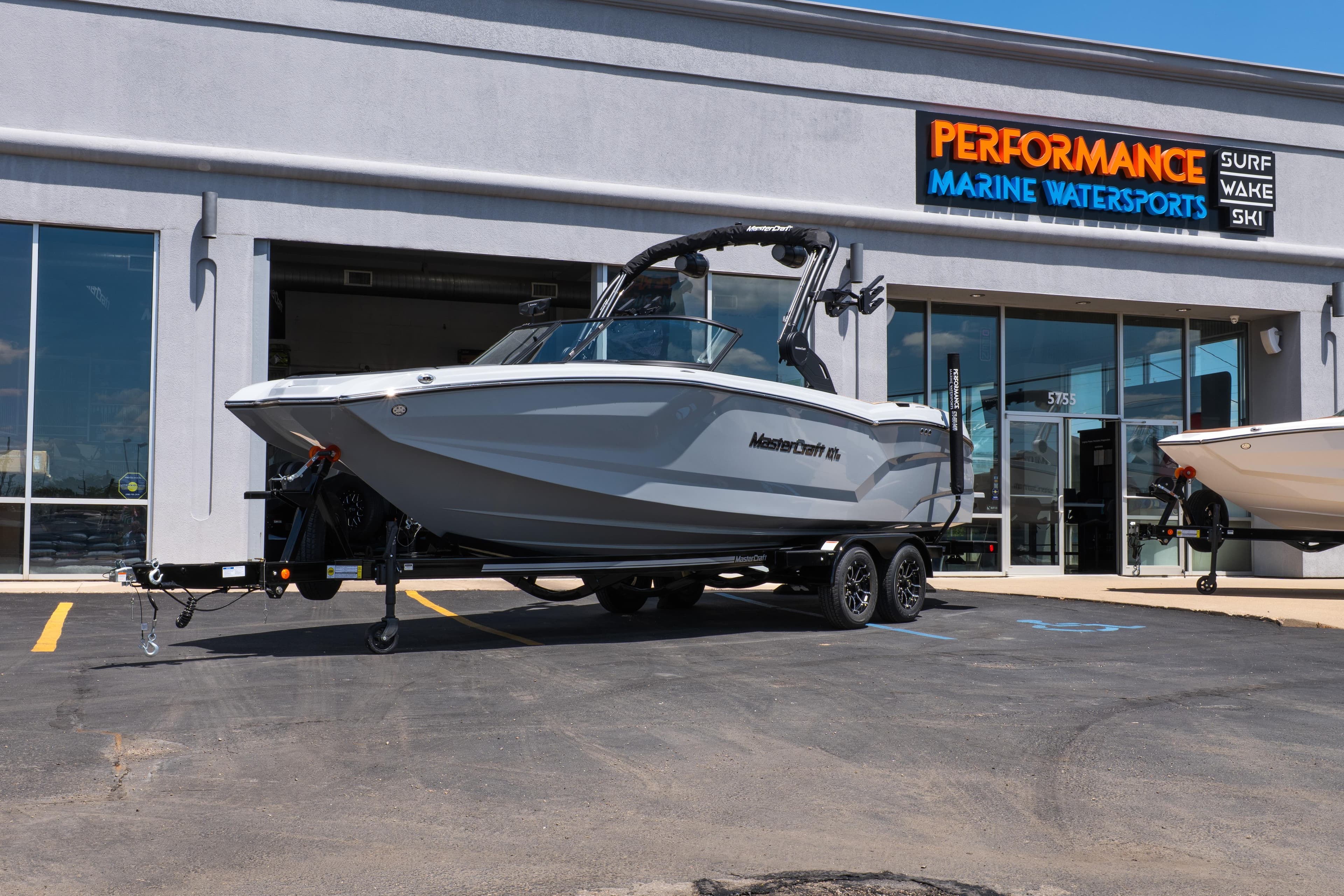 2026 MasterCraft NXT24 boat on trailer outside Performance Marine Watersports dealership.