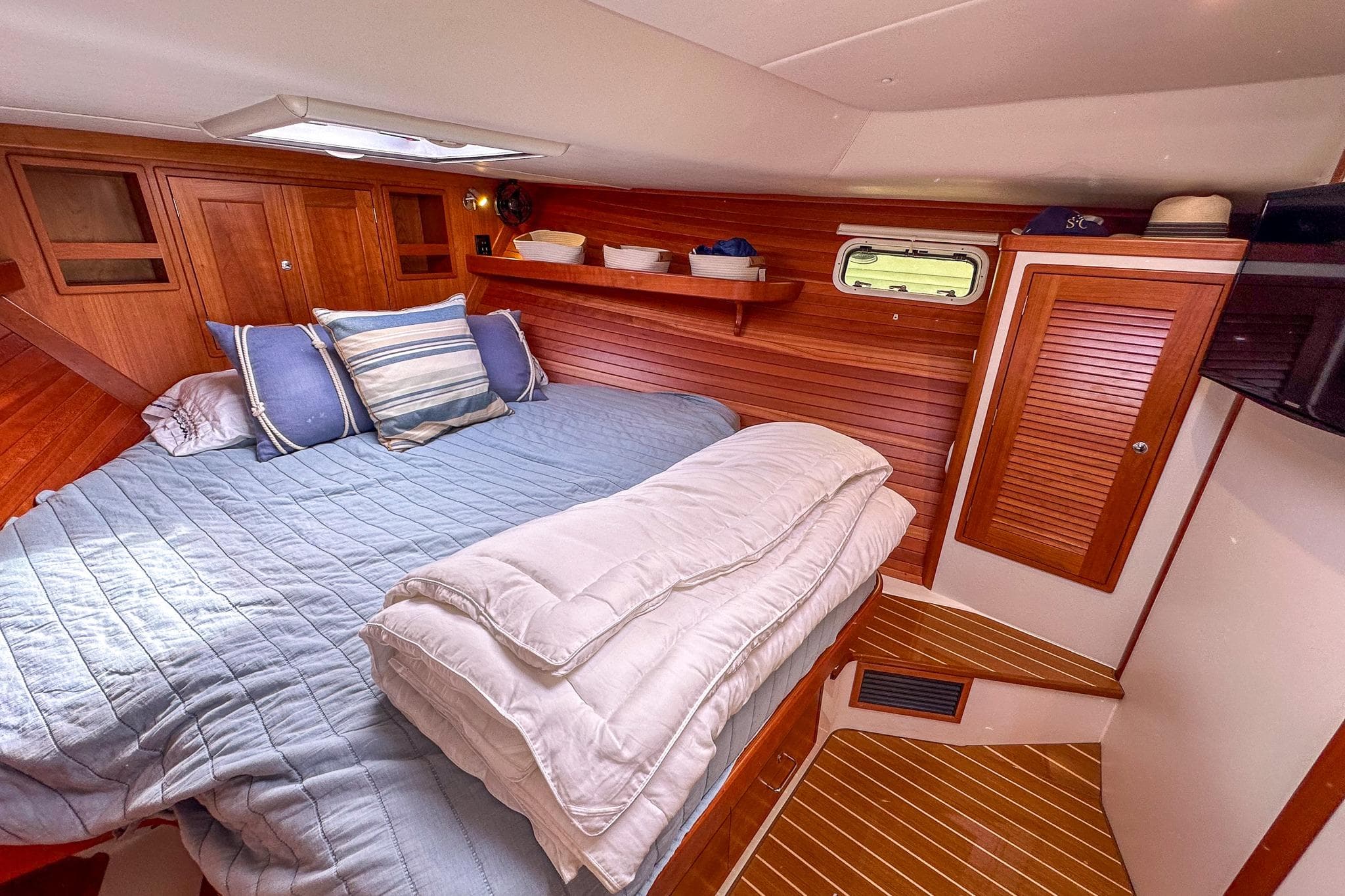 Luxurious 2017 MJM 50z yacht cabin with cozy bedding and elegant wood paneling.