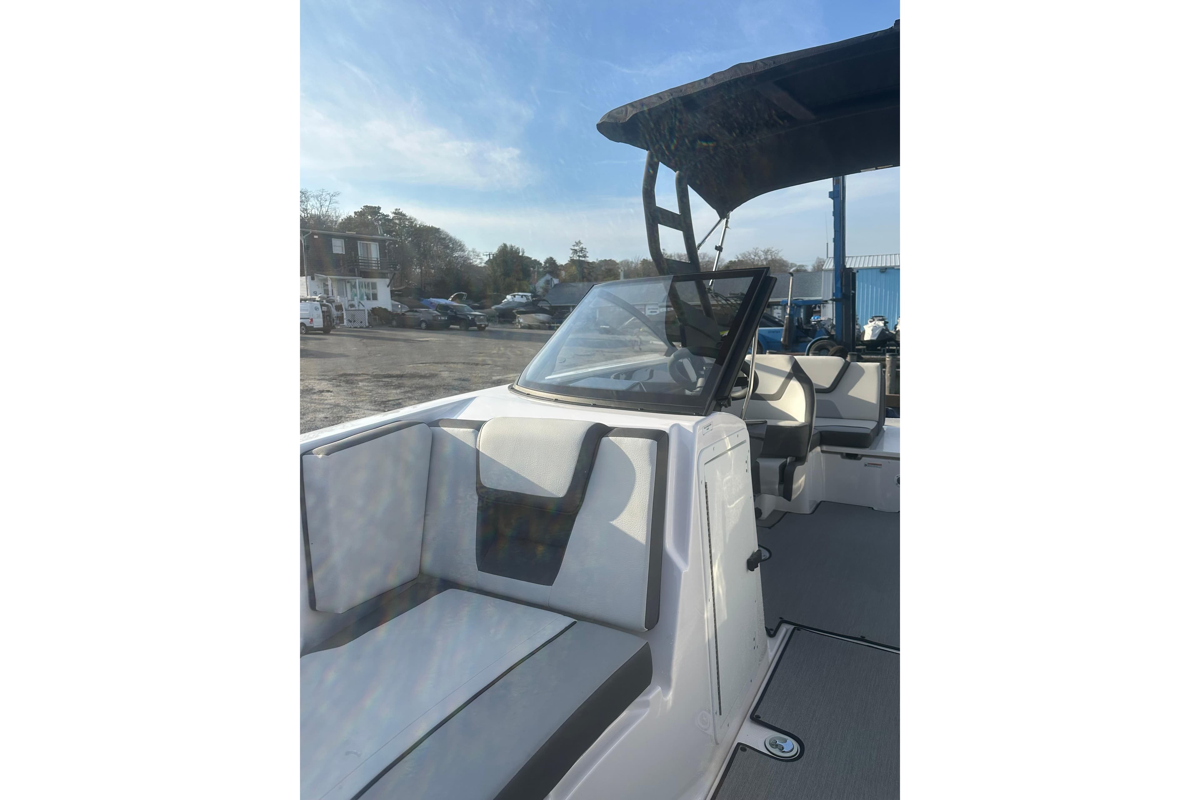 2025 Yamaha Boats AR220 interior with seating and canopy under clear sky.