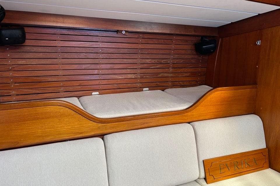 Interior of 1982 Nautor Swan 65 yacht with wooden paneling and cushioned seating.