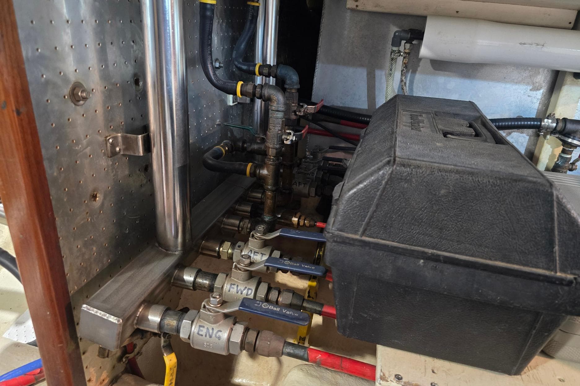 Engine room of 1989 Offshore Yachts 48 Sedan with visible piping and valves.