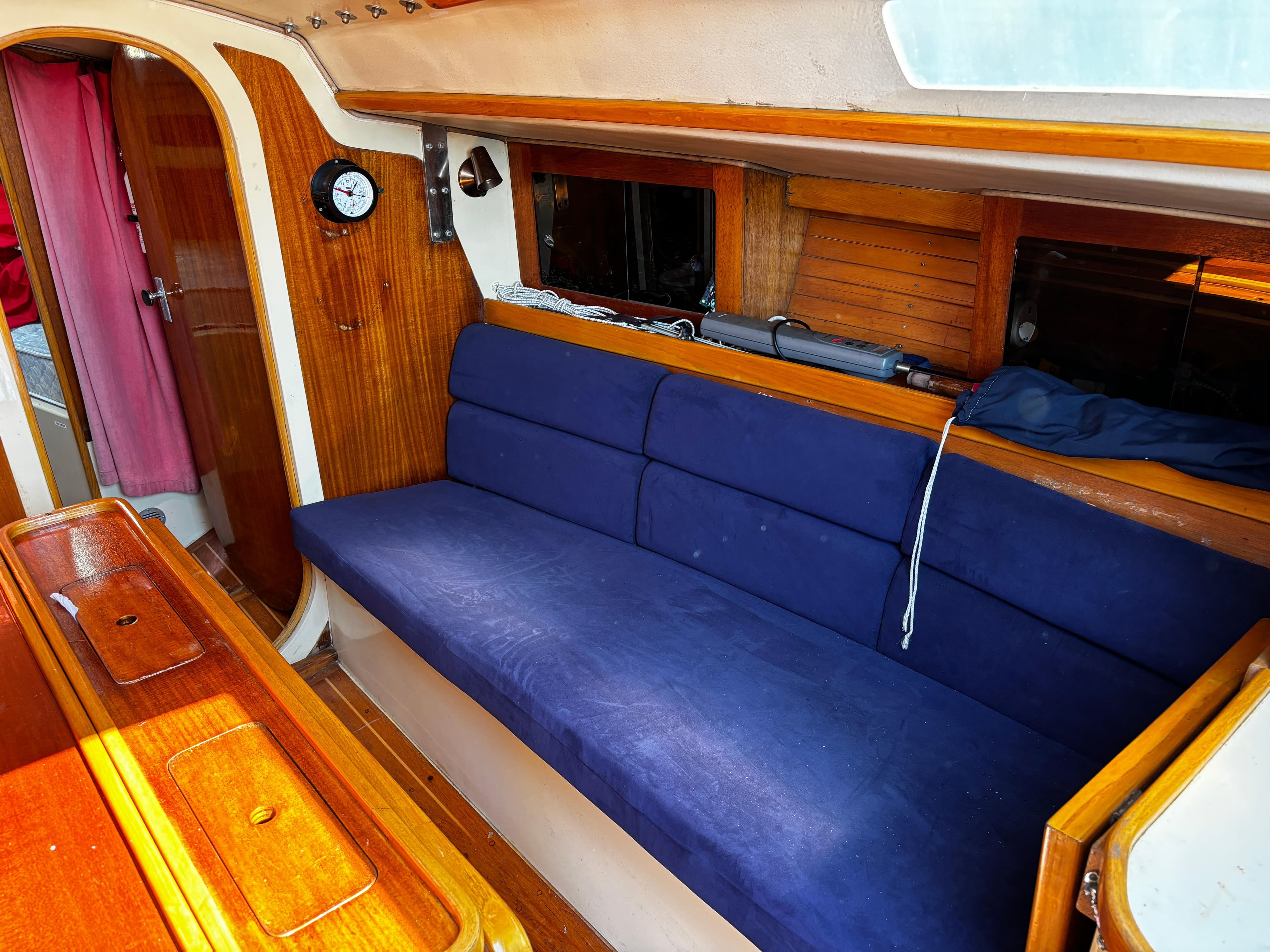 1982 J Boats 30 interior with blue cushioned seating and wooden accents.