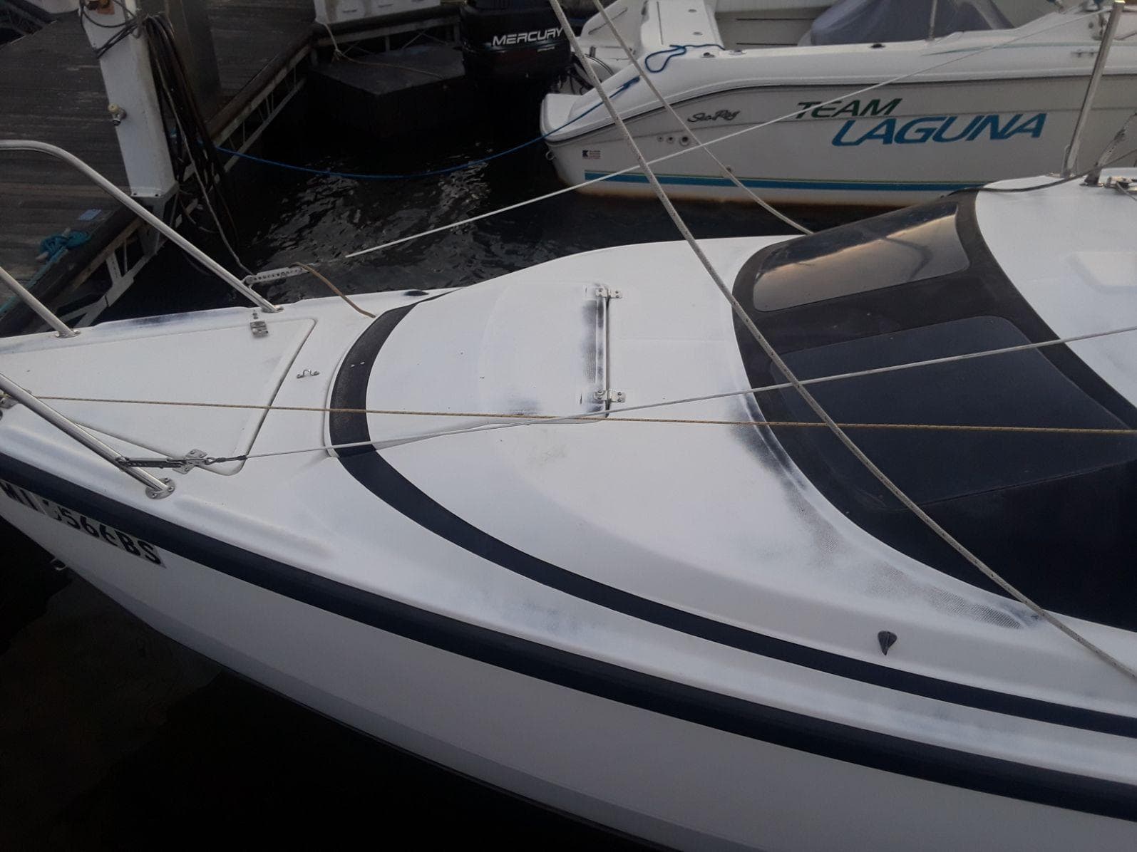 1996 MacGregor 26 "X" sailboat docked, featuring sleek white design and rigging.