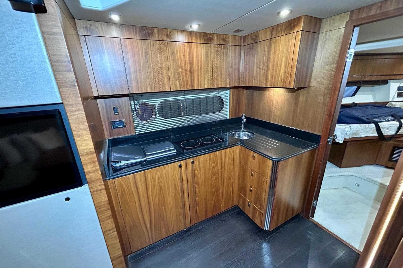 Luxurious 2014 Sunseeker San Remo 485 yacht interior kitchen with wood cabinetry and modern appliances.