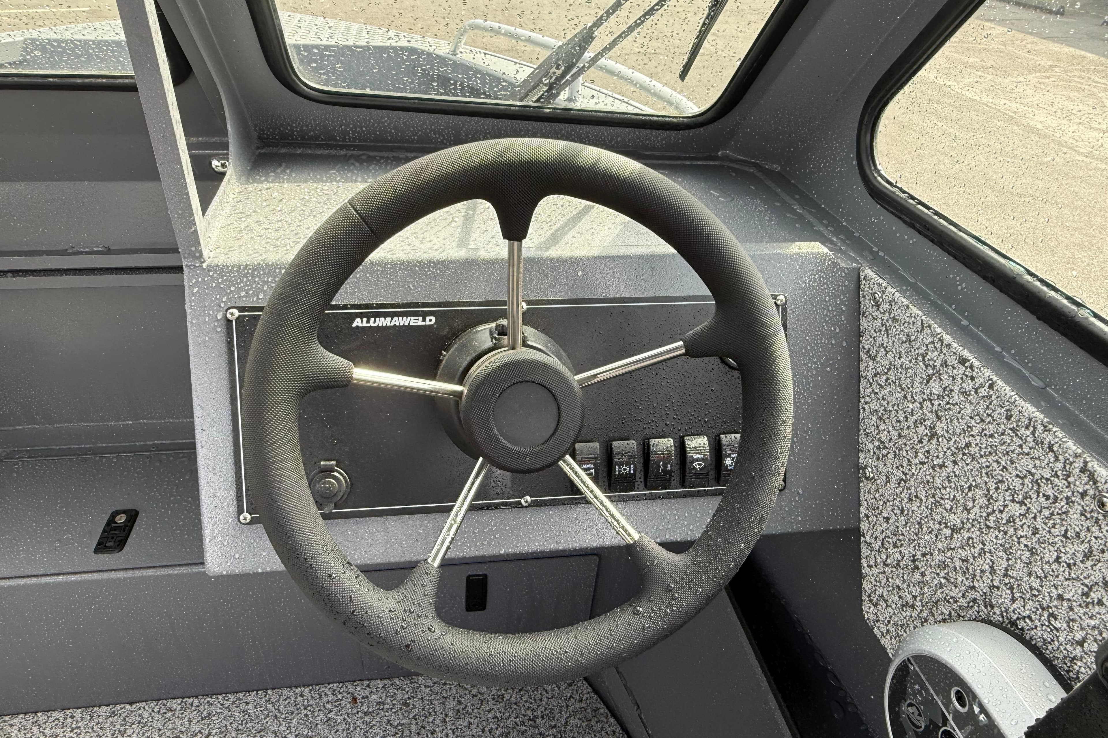 Steering wheel of 2026 Alumaweld Stryker X202 boat, featuring sleek design and controls.