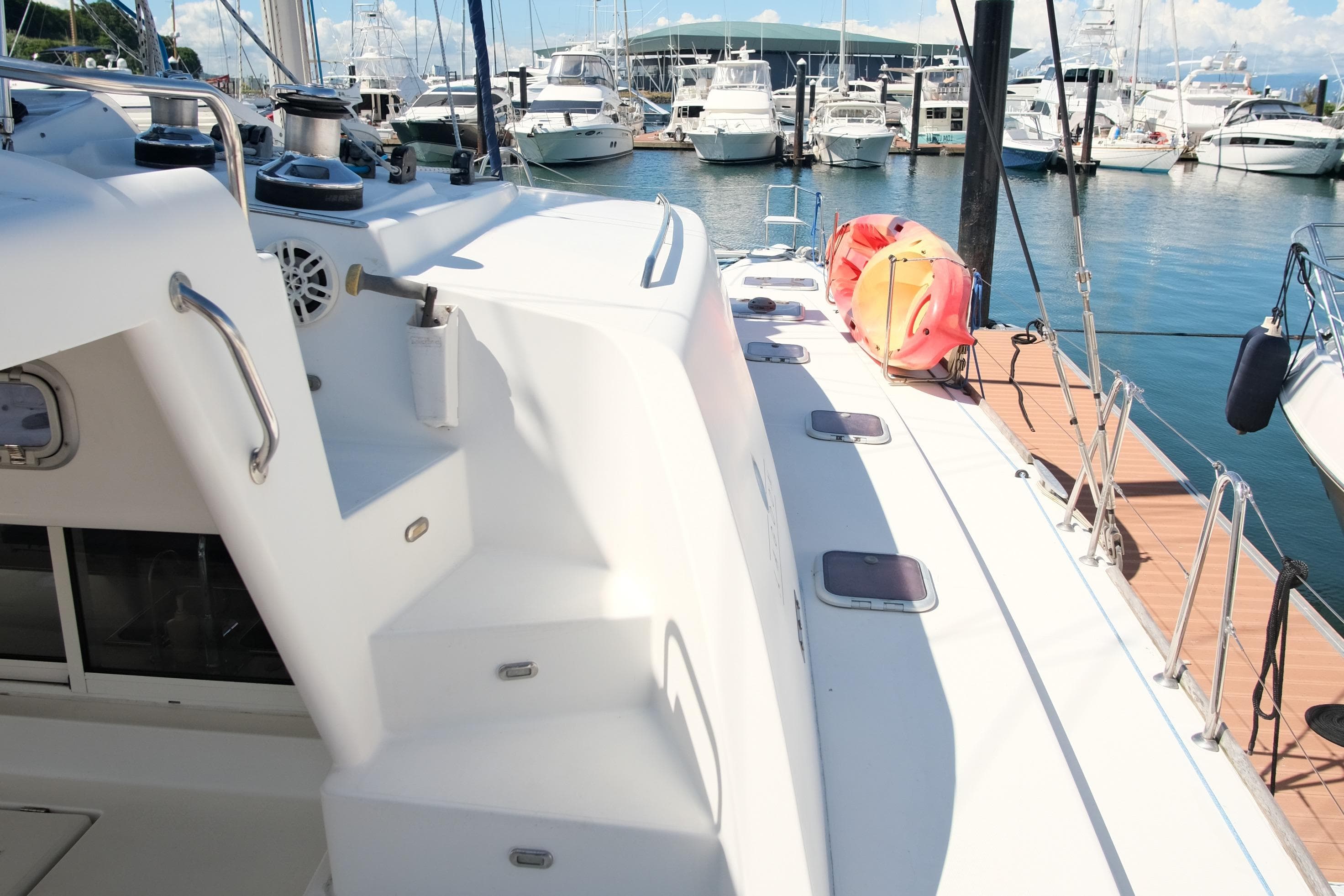Lagoon 440 catamaran docked at marina, showcasing deck and nearby boats, 2002 model.