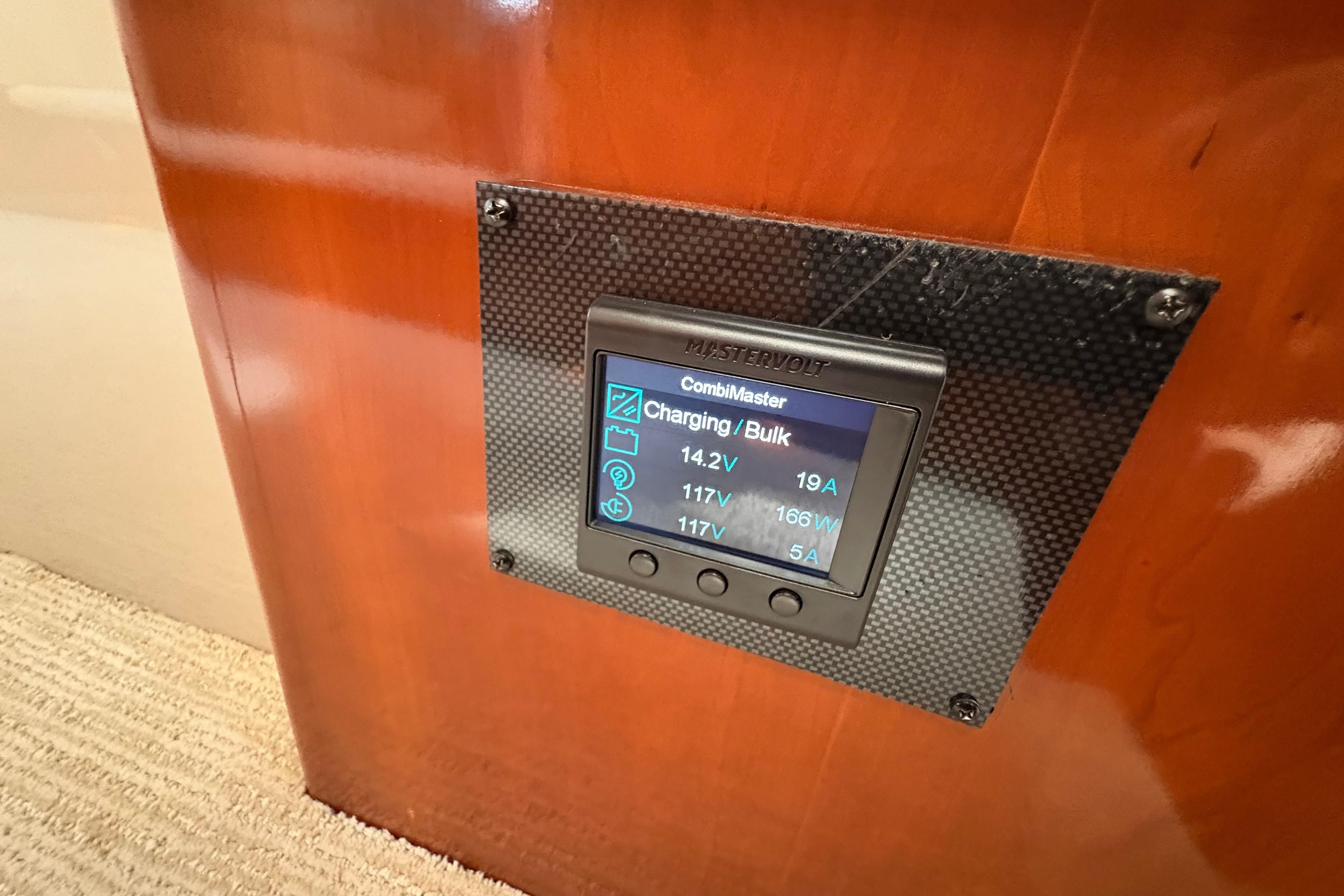 Mastervolt CombiMaster display on 2004 Carver 560 Voyager, showing charging status and voltage.