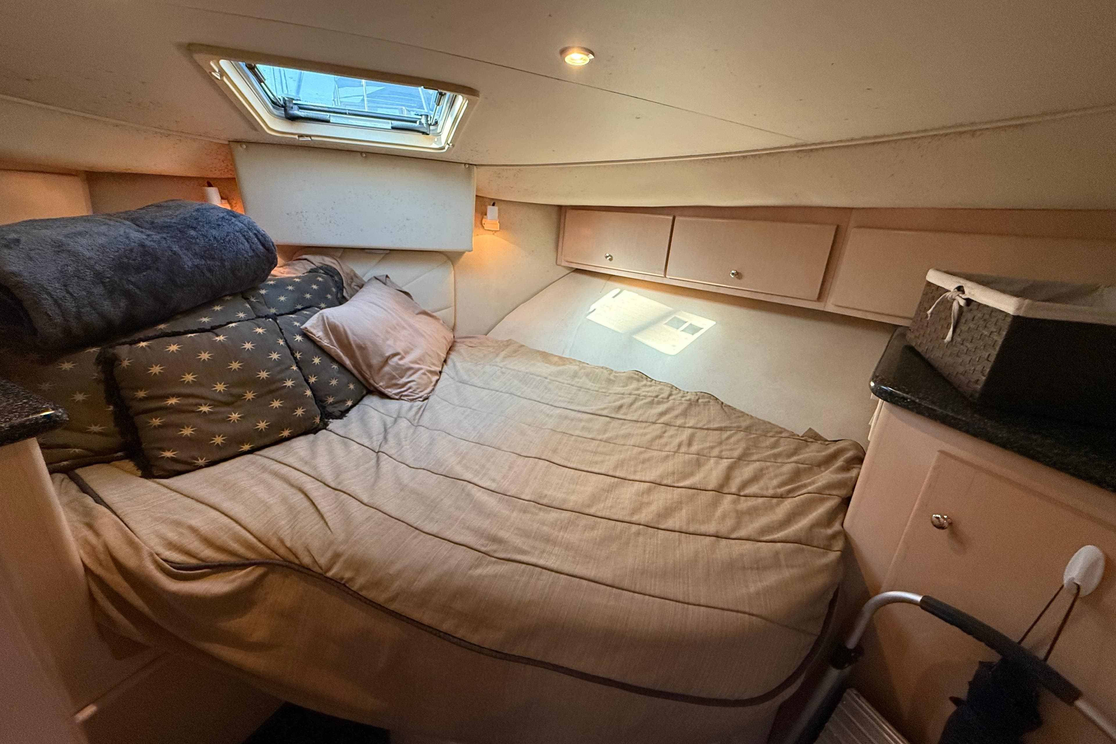 Cozy cabin interior of 1999 Carver 406 Aft Cabin Motor Yacht with bed and storage.