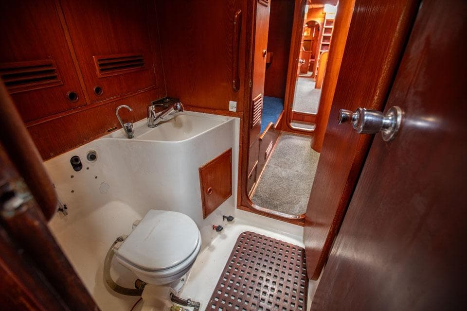 1983 Nautor Swan 65 yacht bathroom with wooden interior and compact fixtures.