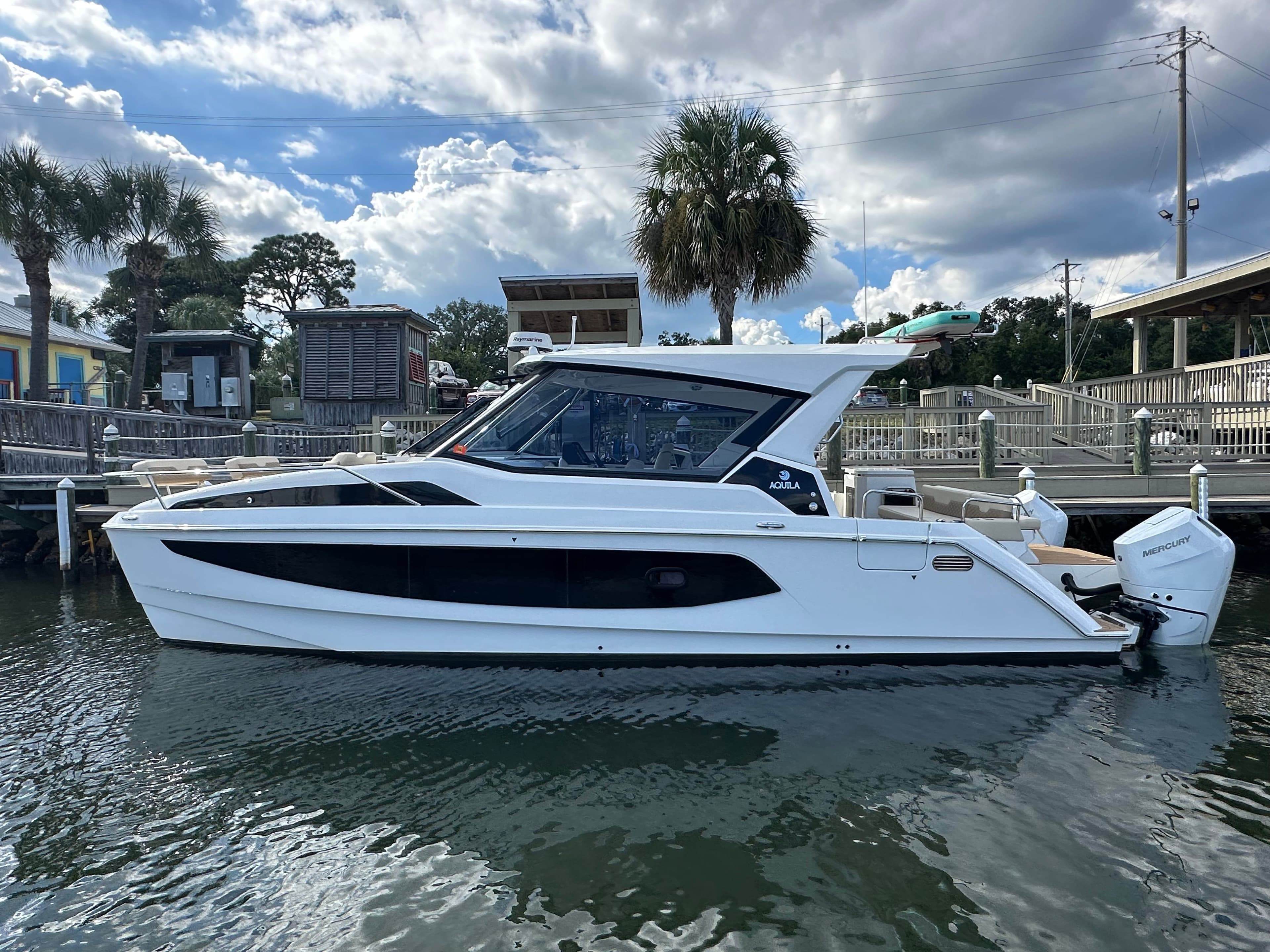 2025 Aquila 36 Sport boat docked, featuring sleek design and modern amenities.