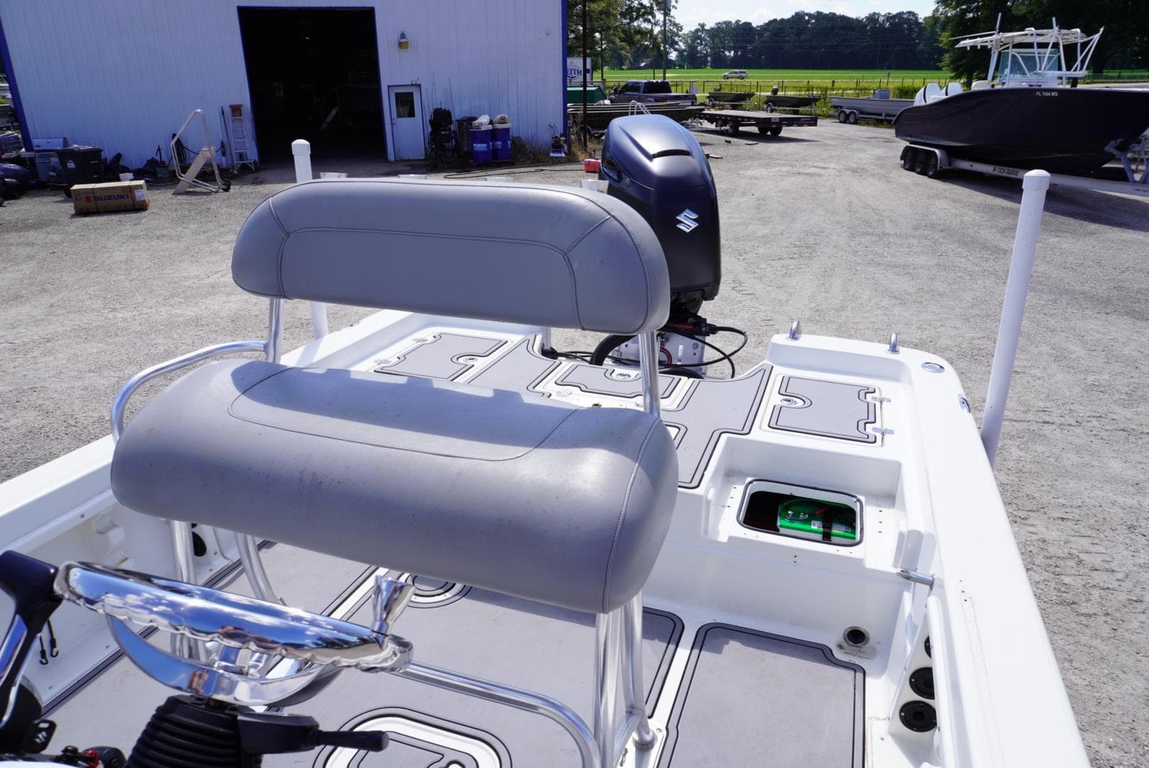 2014 NauticStar 244 XTS boat with Suzuki outboard motor in a boatyard.